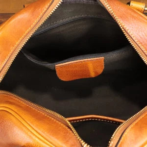 Close-up of a brown leather bag with a zipper