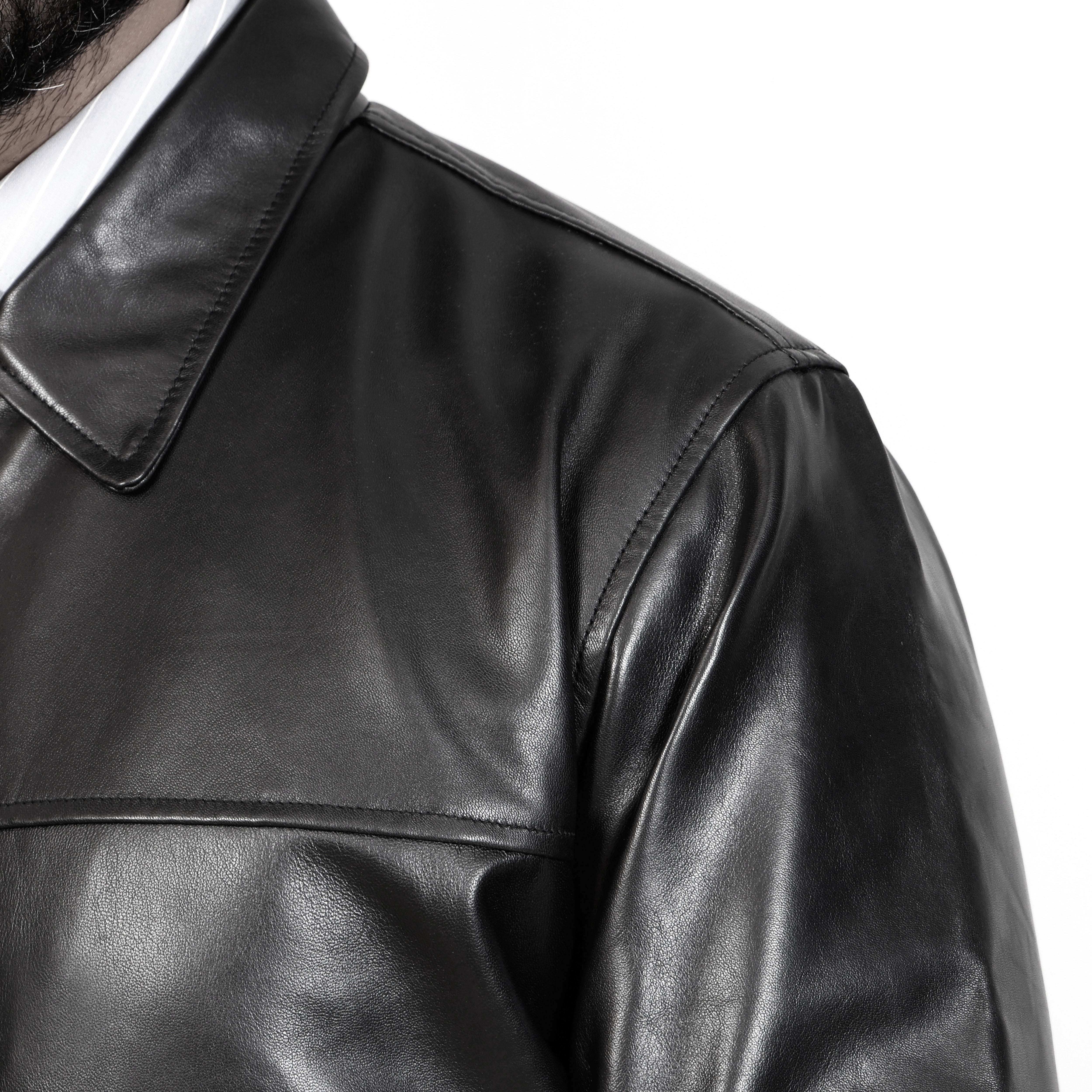 Close-up of a black leather jacket on a white background