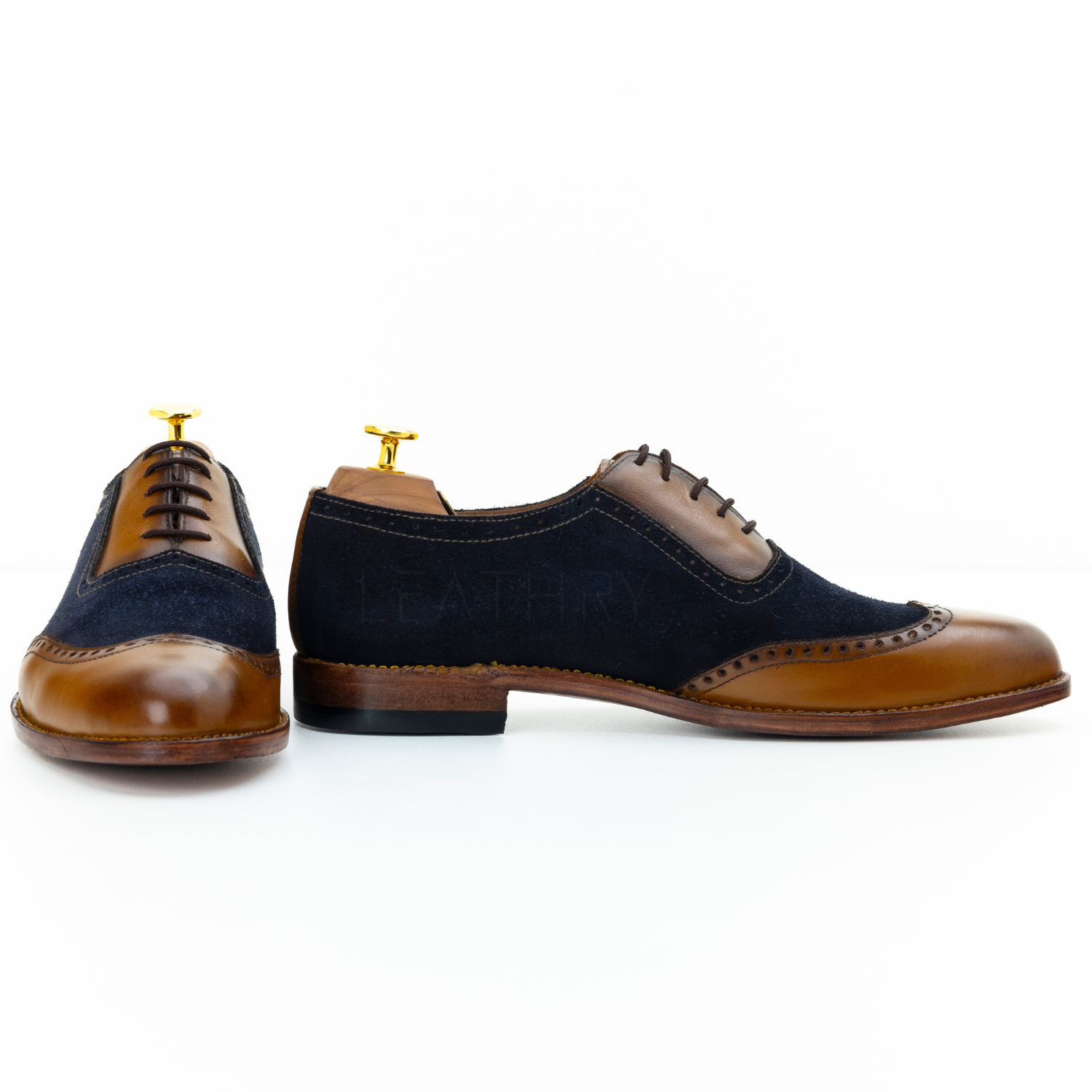 Pair of navy and brown dress shoes on a white background