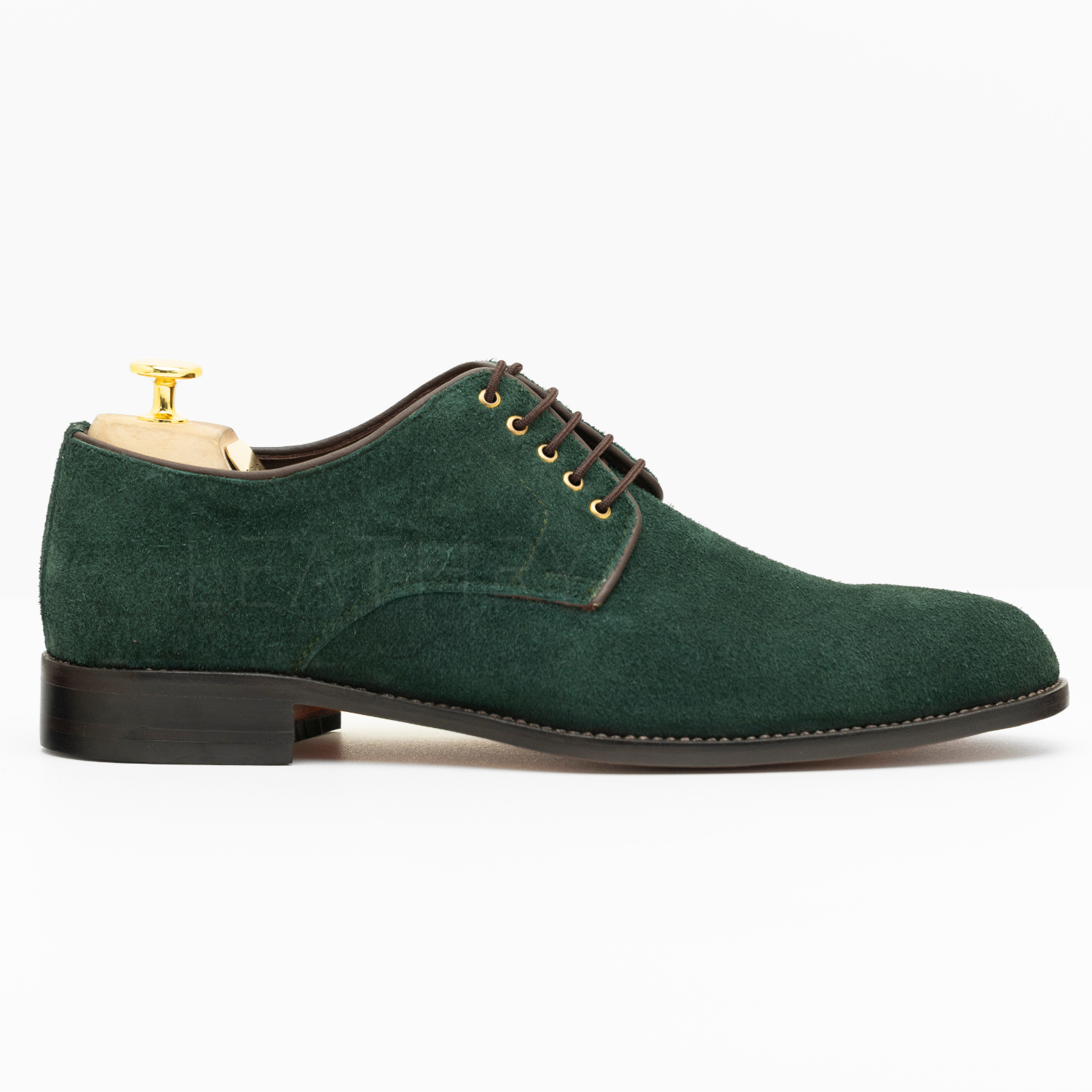 Green suede shoe with brown laces on a white background