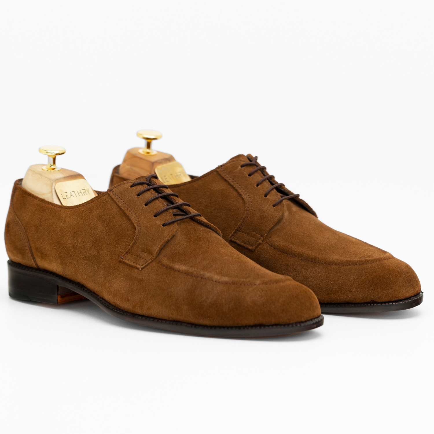 Brown suede dress shoes on a white background