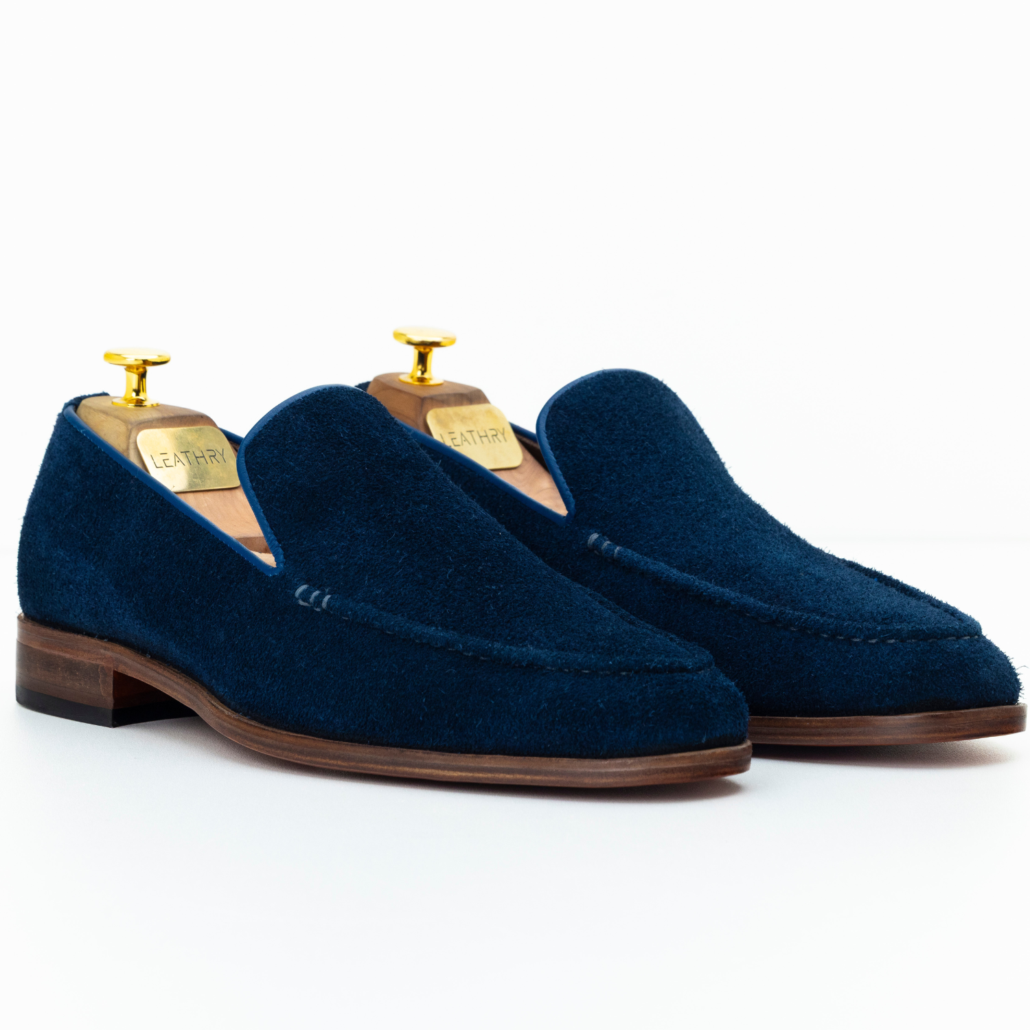 Pair of blue suede loafers on a white background