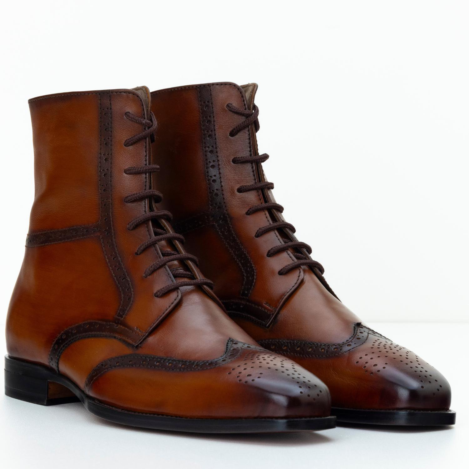Pair of brown leather dress boots on a white background