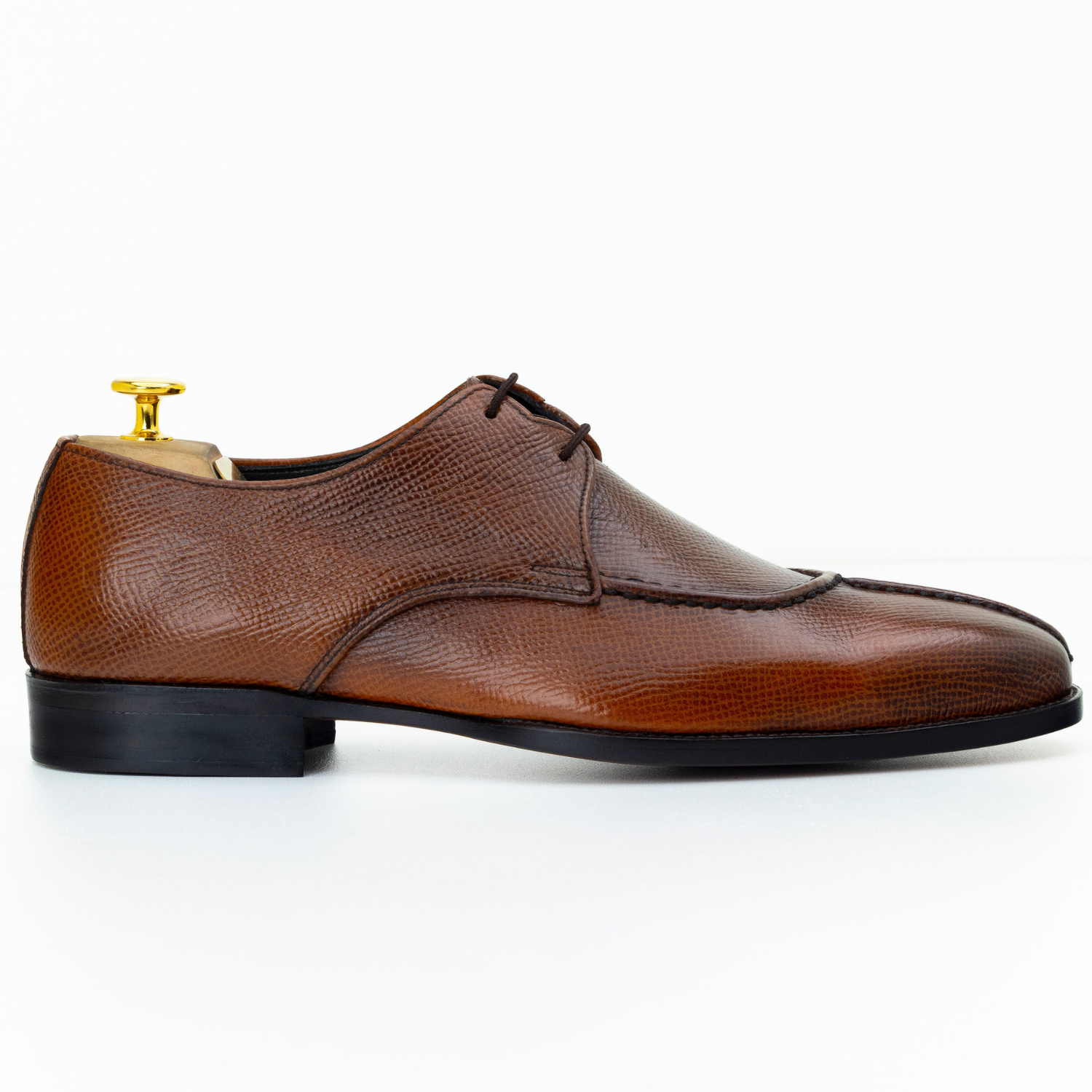 Brown leather dress shoe on a white background