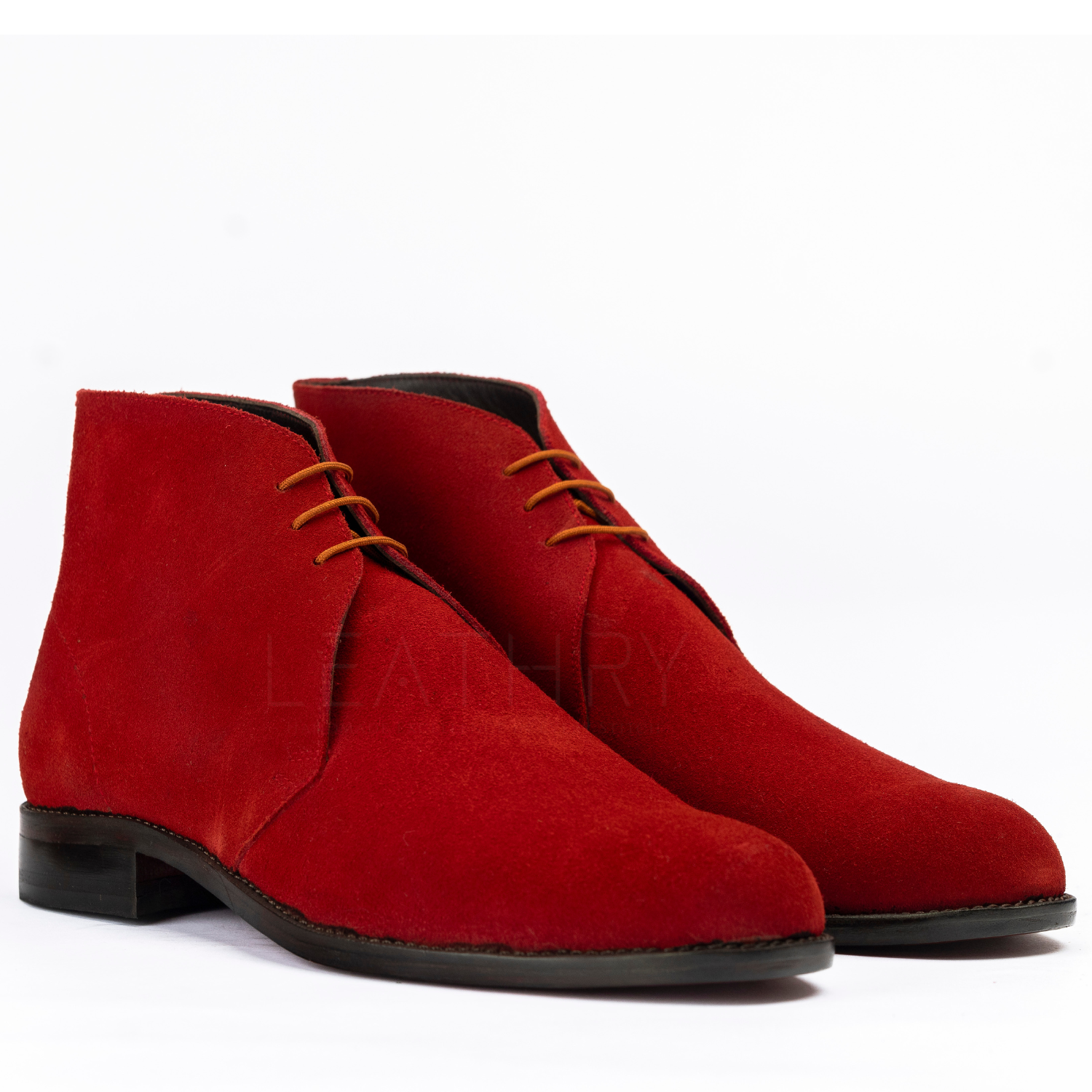 Red suede boots with brown laces on a white background