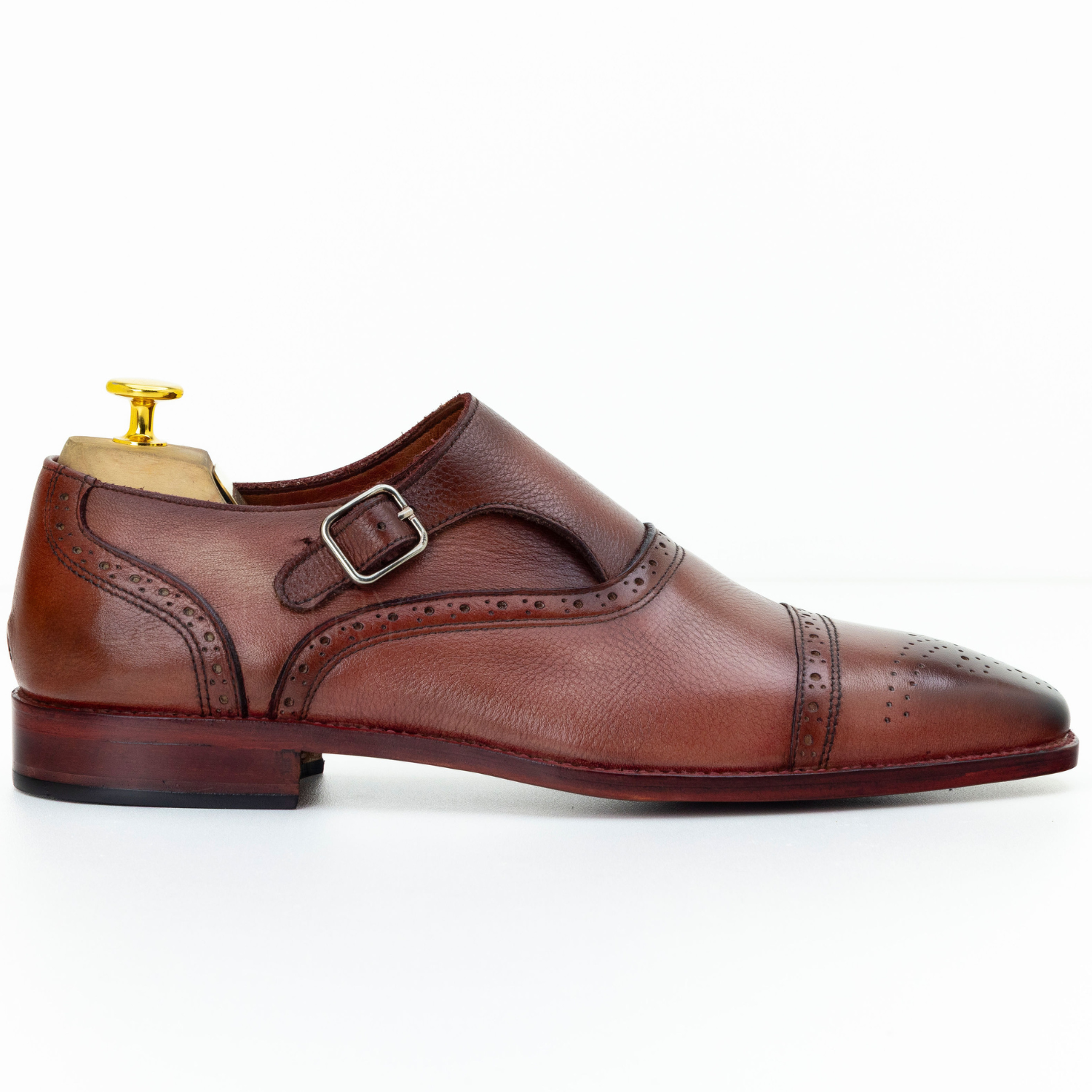 Brown leather dress shoe with a buckle on a white background
