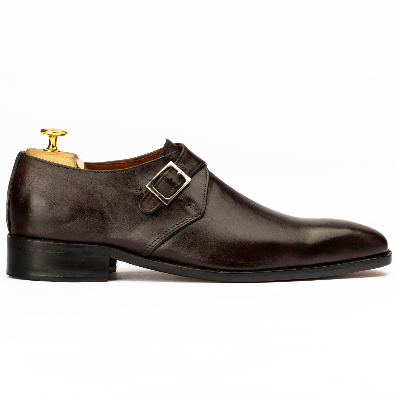 Brown leather dress shoe with a buckle on a white background