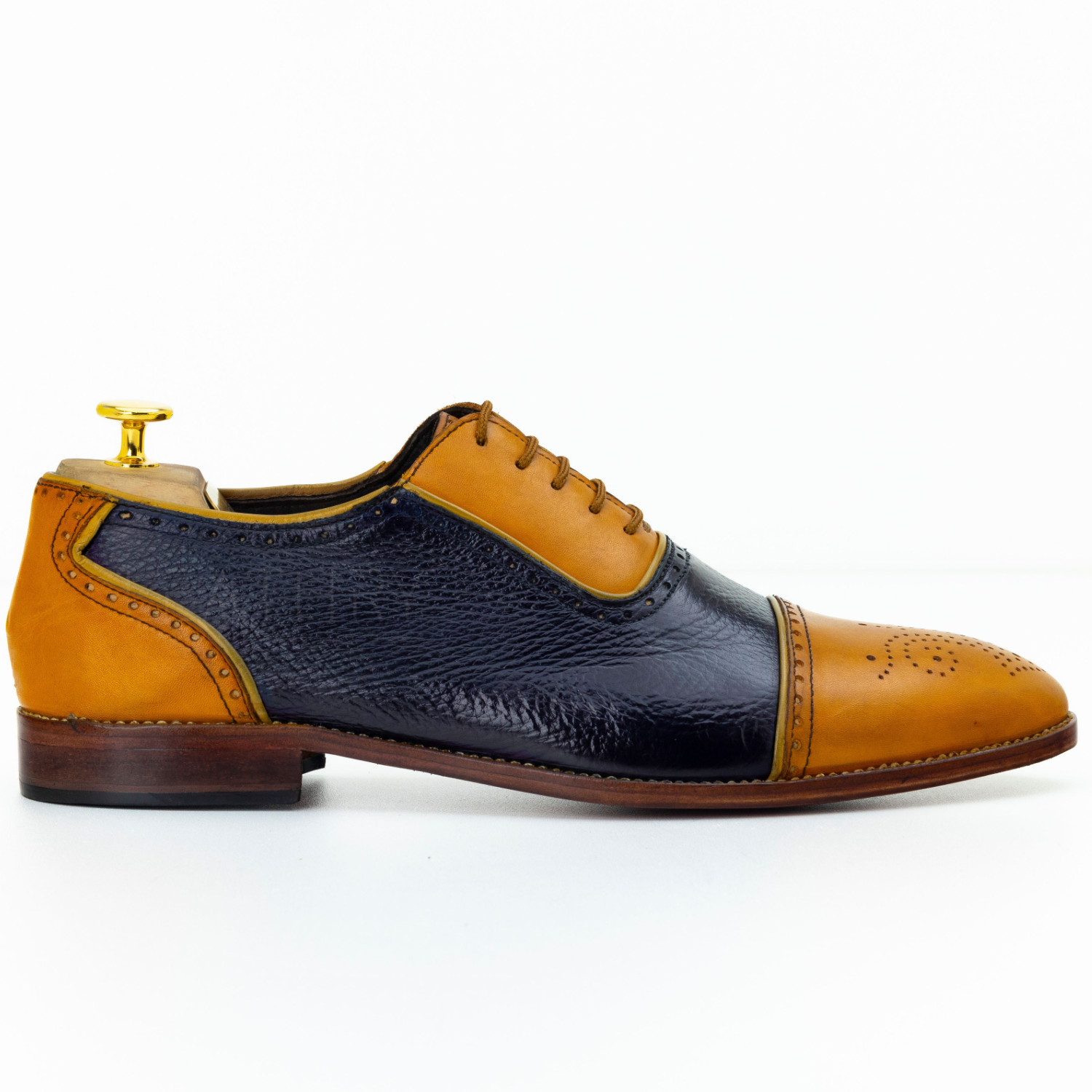 Two-tone leather shoe with brown and navy design on a white background