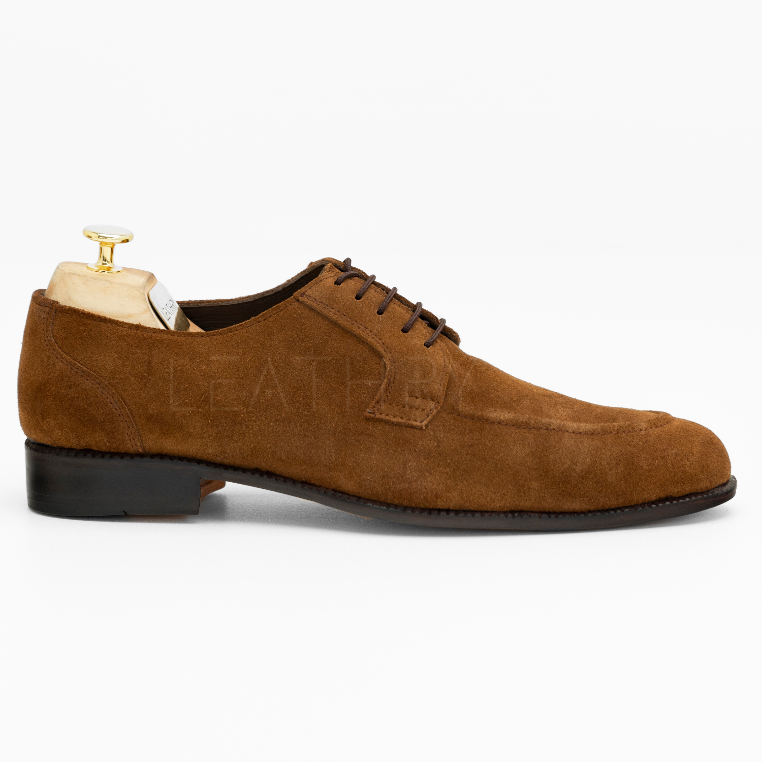 Brown suede dress shoe on a white background