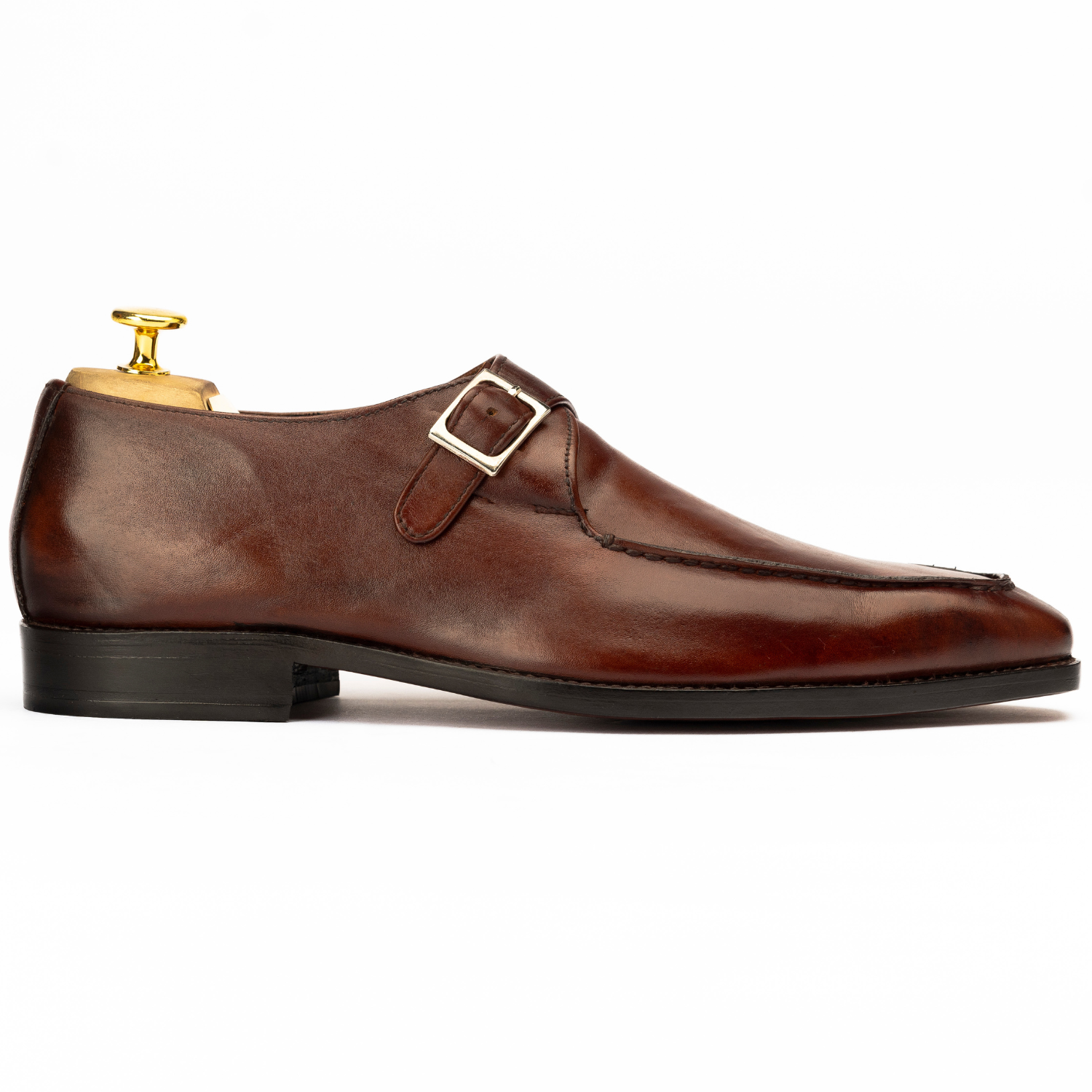 Brown leather dress shoe with gold buckle on a white background