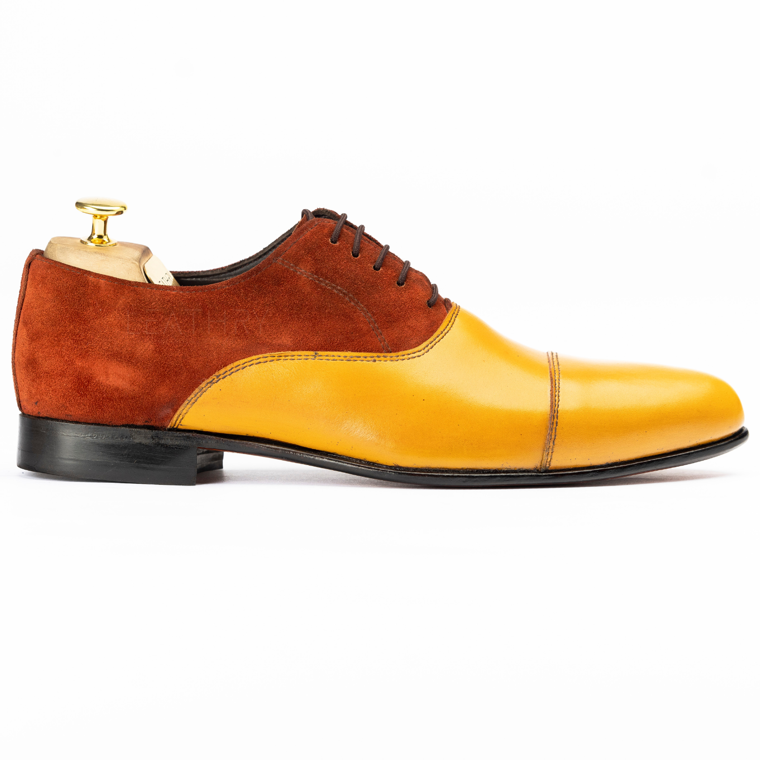Brown and yellow dress shoe on a white background