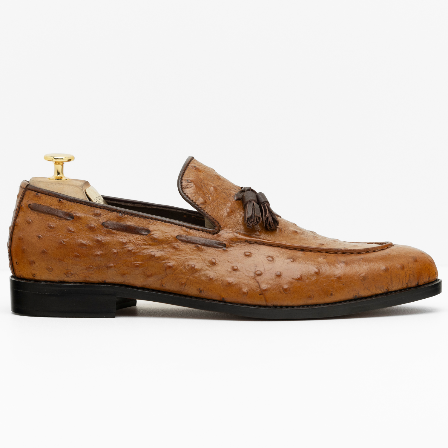 Brown leather loafer with tassel on a white background