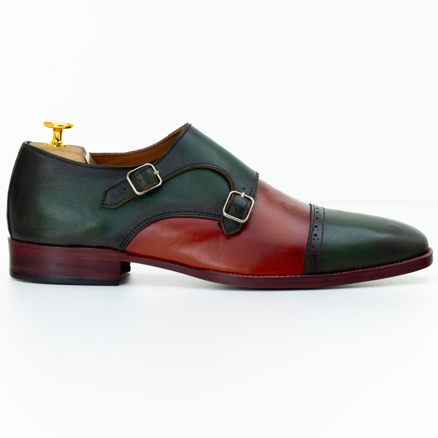 Two-tone green and red leather shoe with gold buckle on a white background