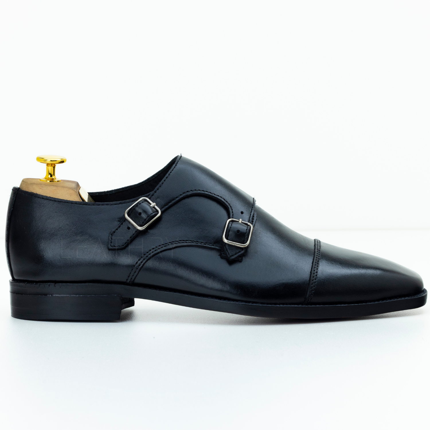 Black leather double-buckle shoe on a white background