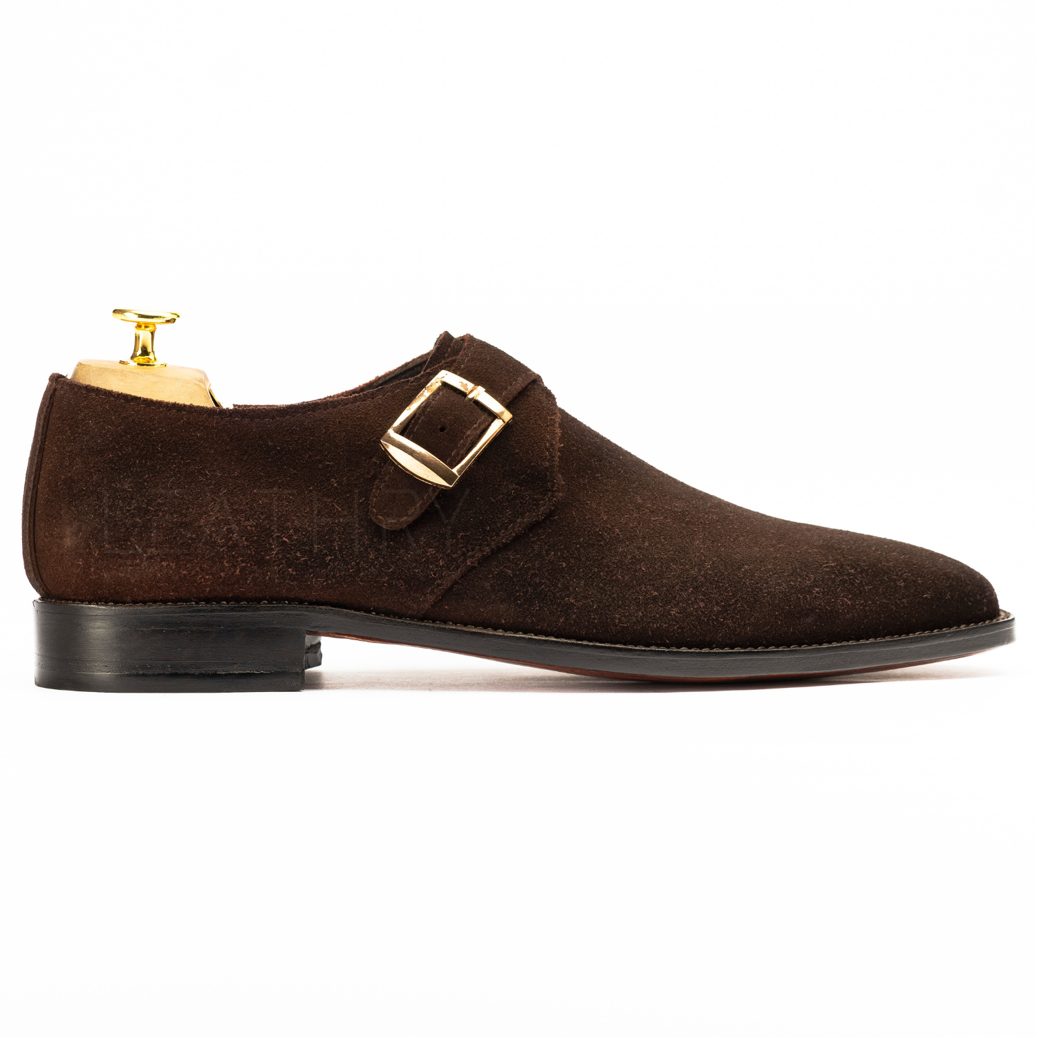 Brown suede dress shoe with gold buckle on a white background