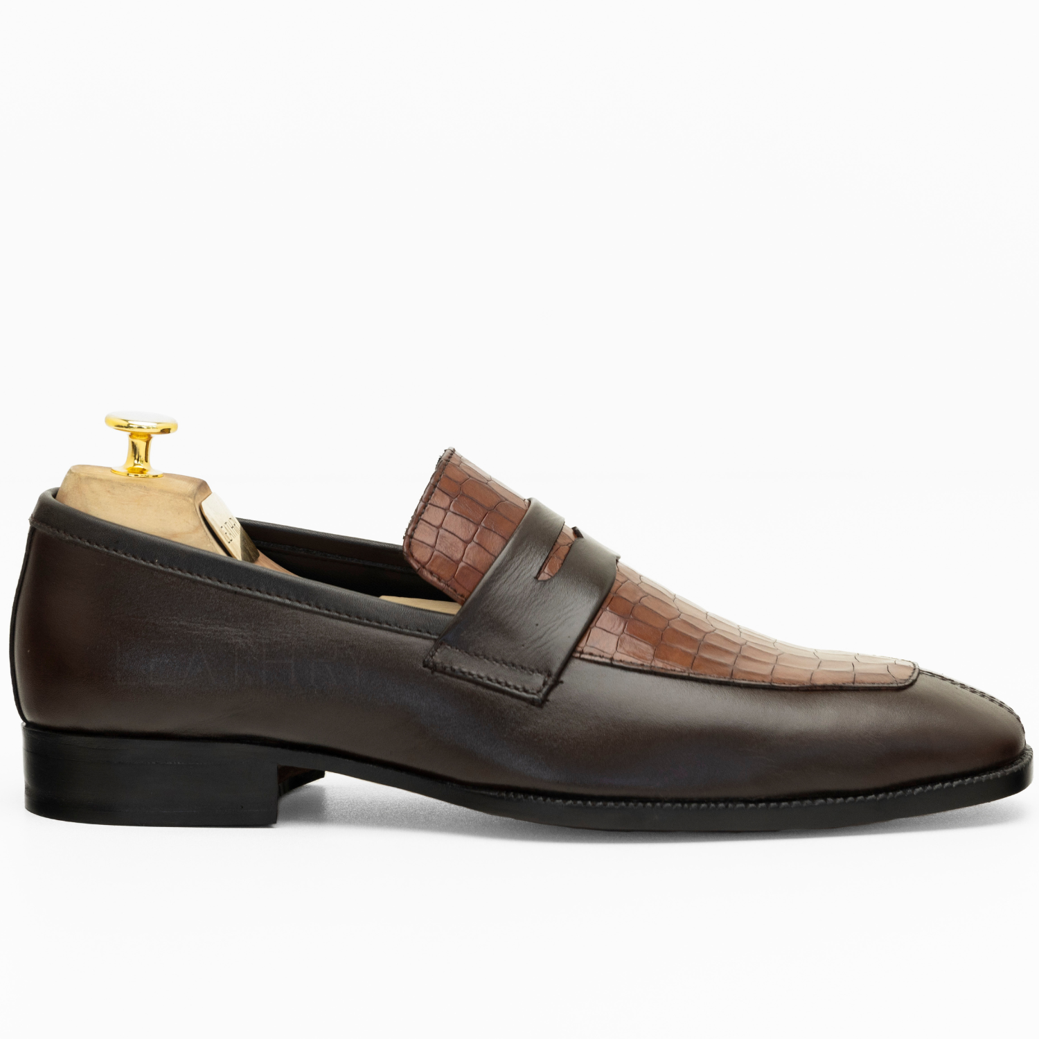 Brown leather loafer with crocodile texture on a white background