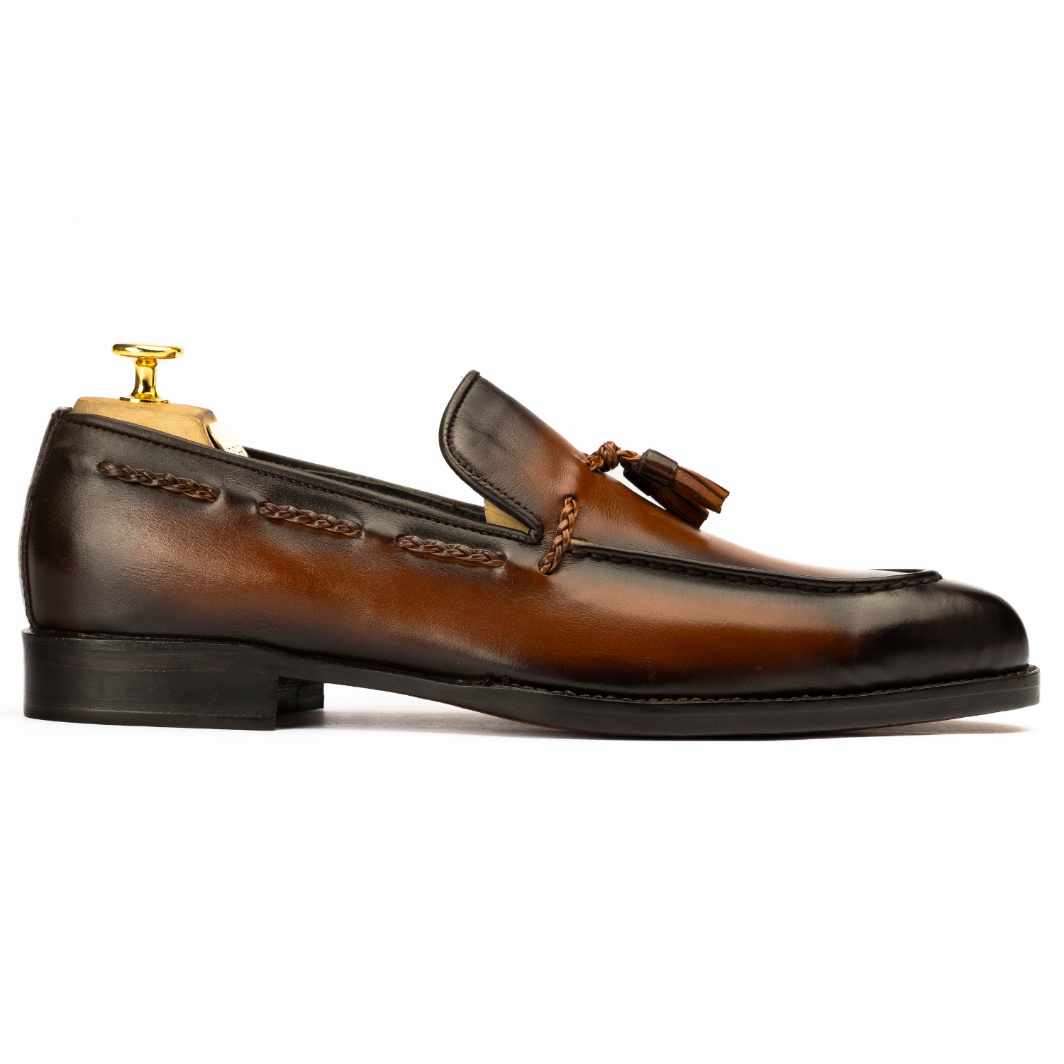 Brown leather loafer with tassel on a white background