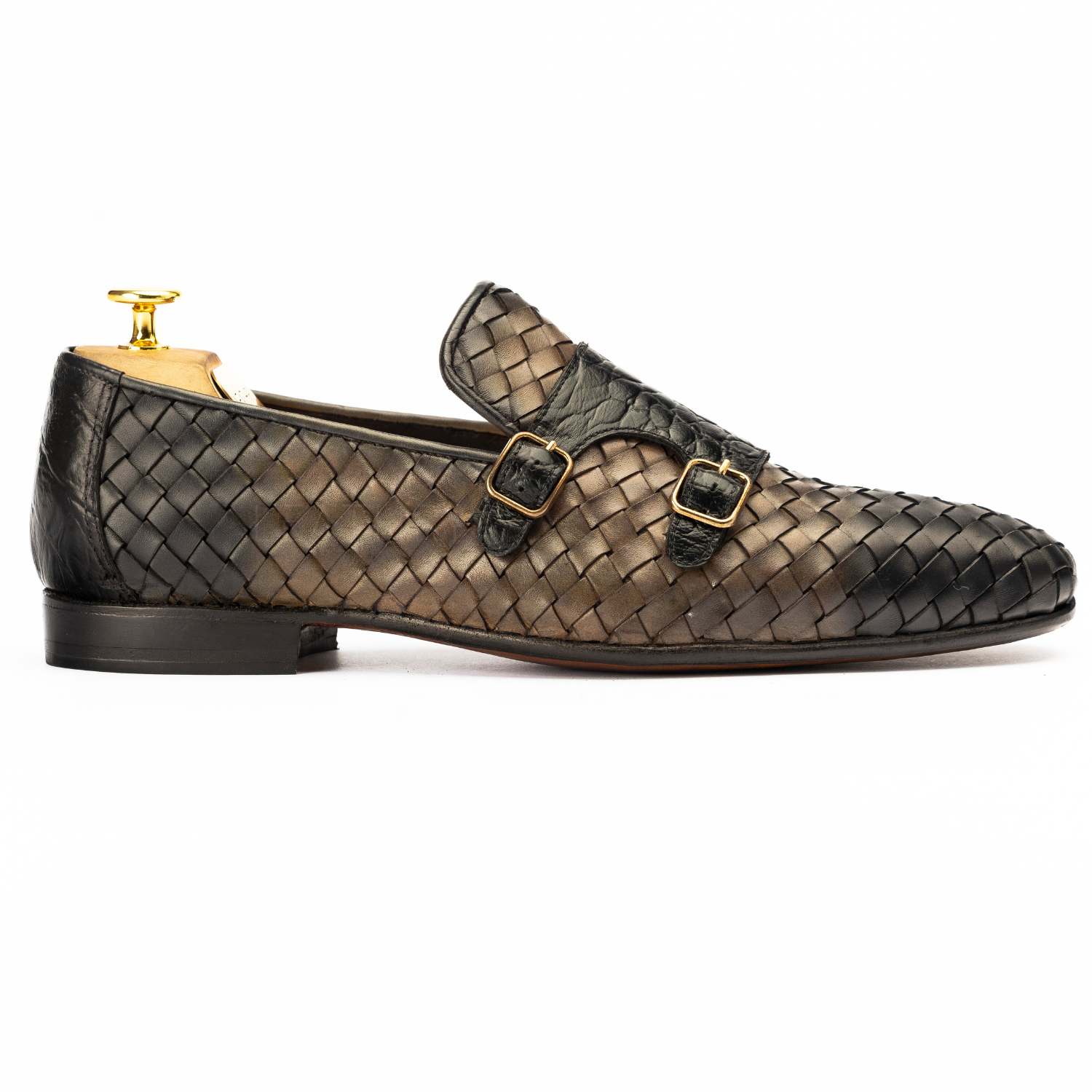 Woven leather shoes with gold buckles on a white background