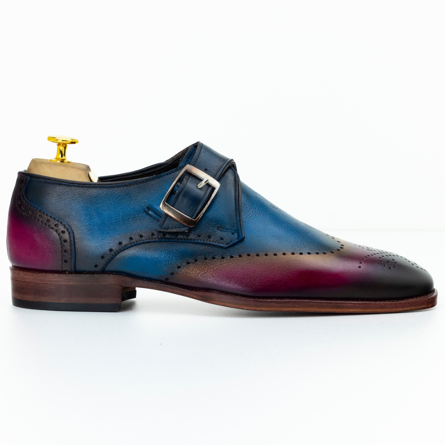Blue and red ombre dress shoe with a buckle on a white background