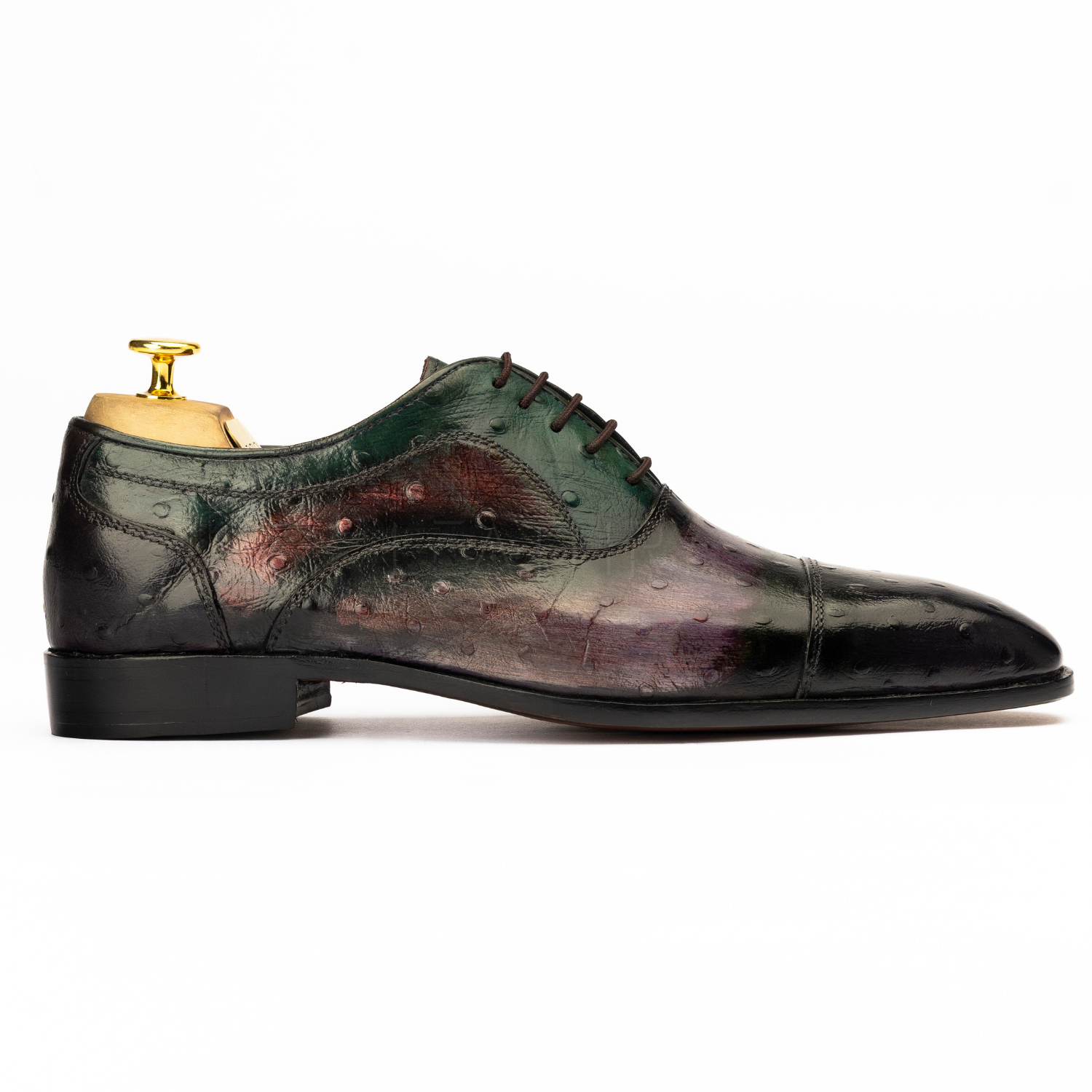 Green leather dress shoe with a worn-in finish on a white background