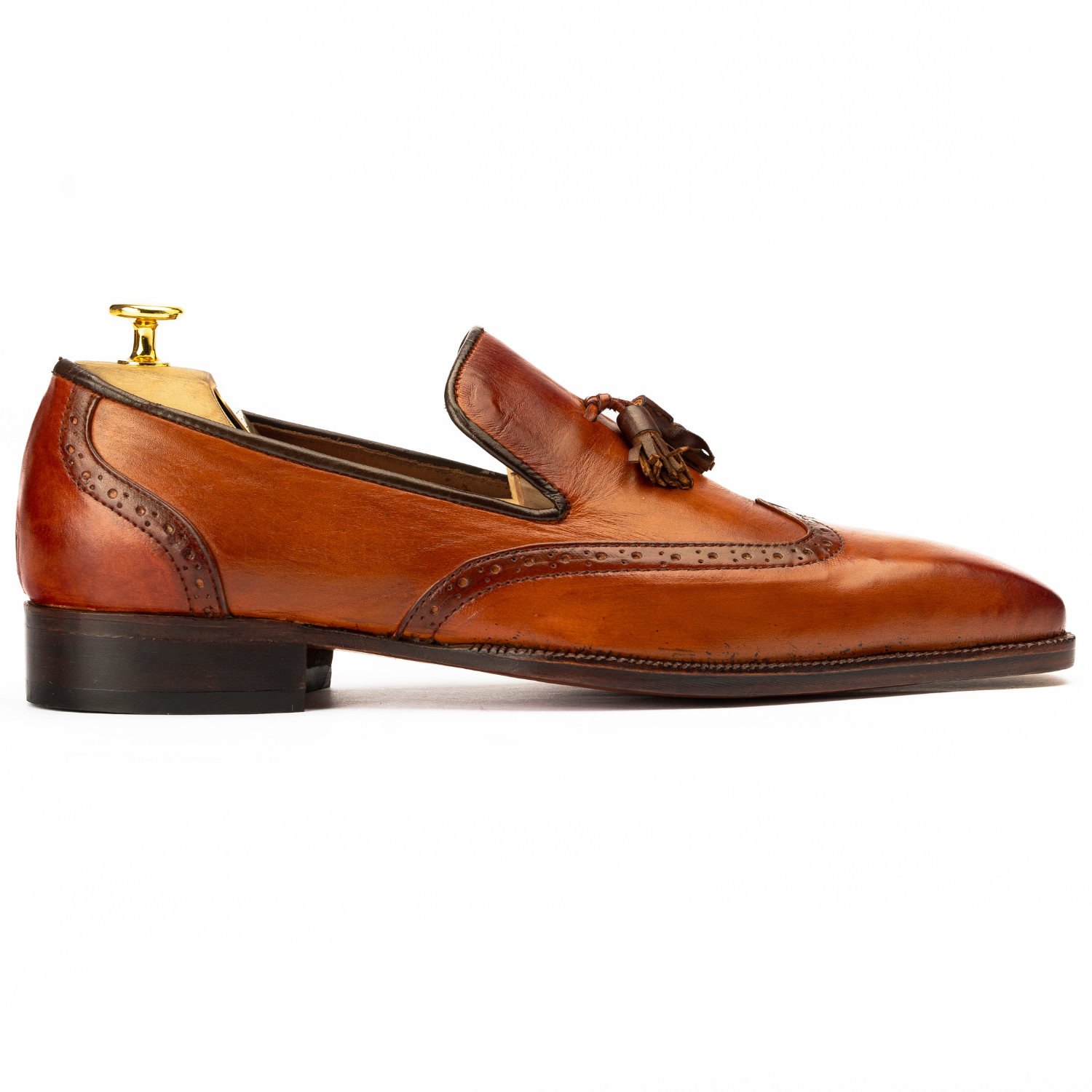 Brown leather loafer with tassel on a white background