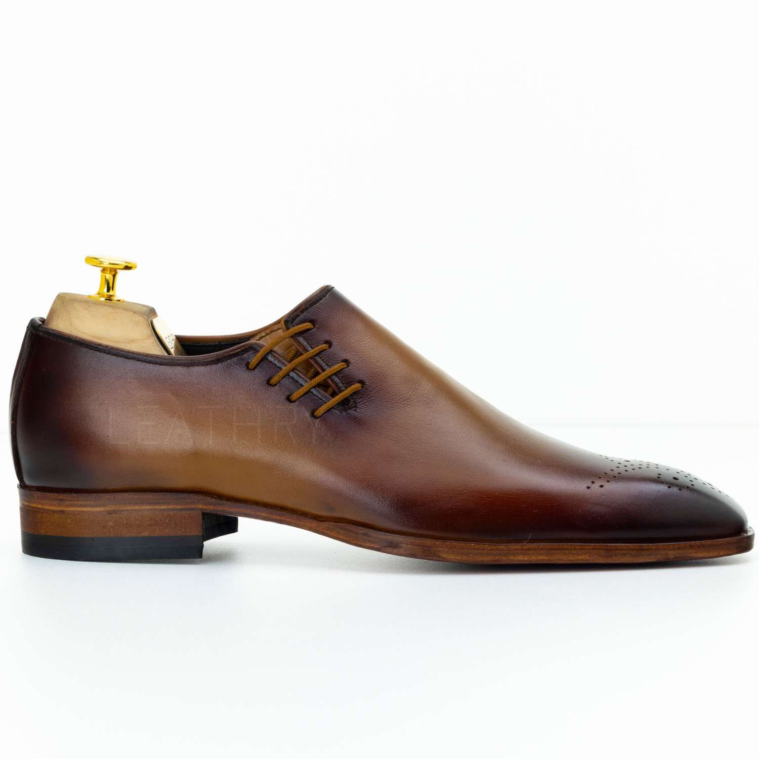 Brown leather dress shoe on a white background