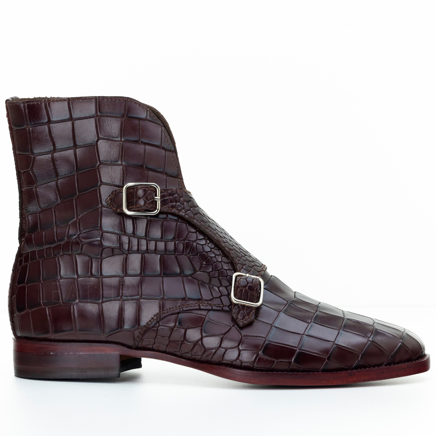 Brown crocodile-patterned leather boot with silver buckles on a white background