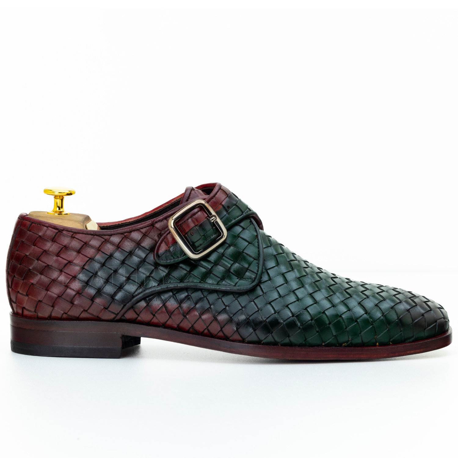 Green and brown woven dress shoe with gold buckle on a white background
