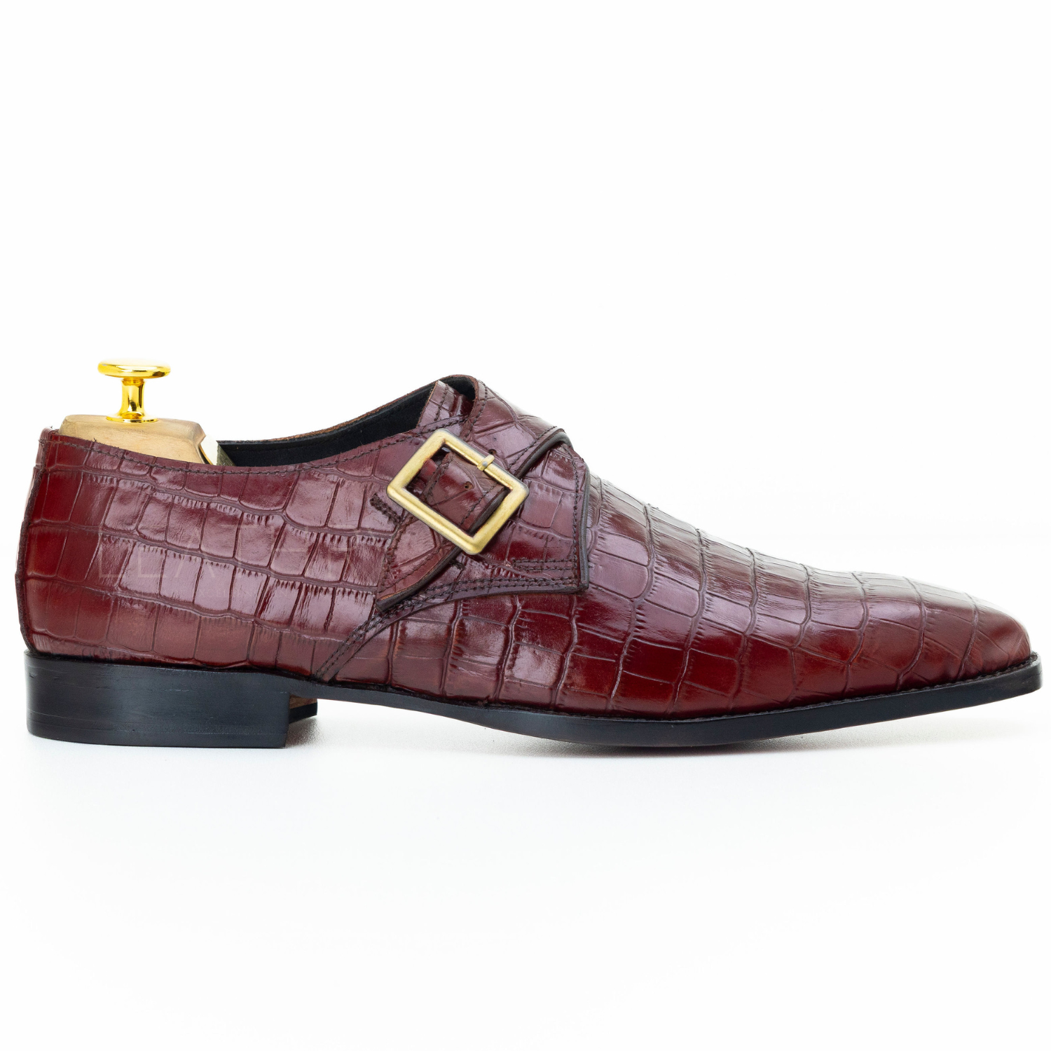 Maroon crocodile-patterned shoe with gold buckle on a white background