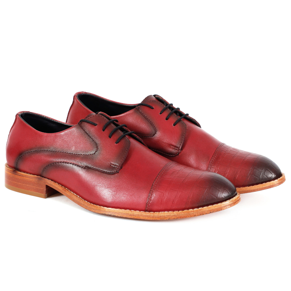 Pair of red leather dress shoes on a white background