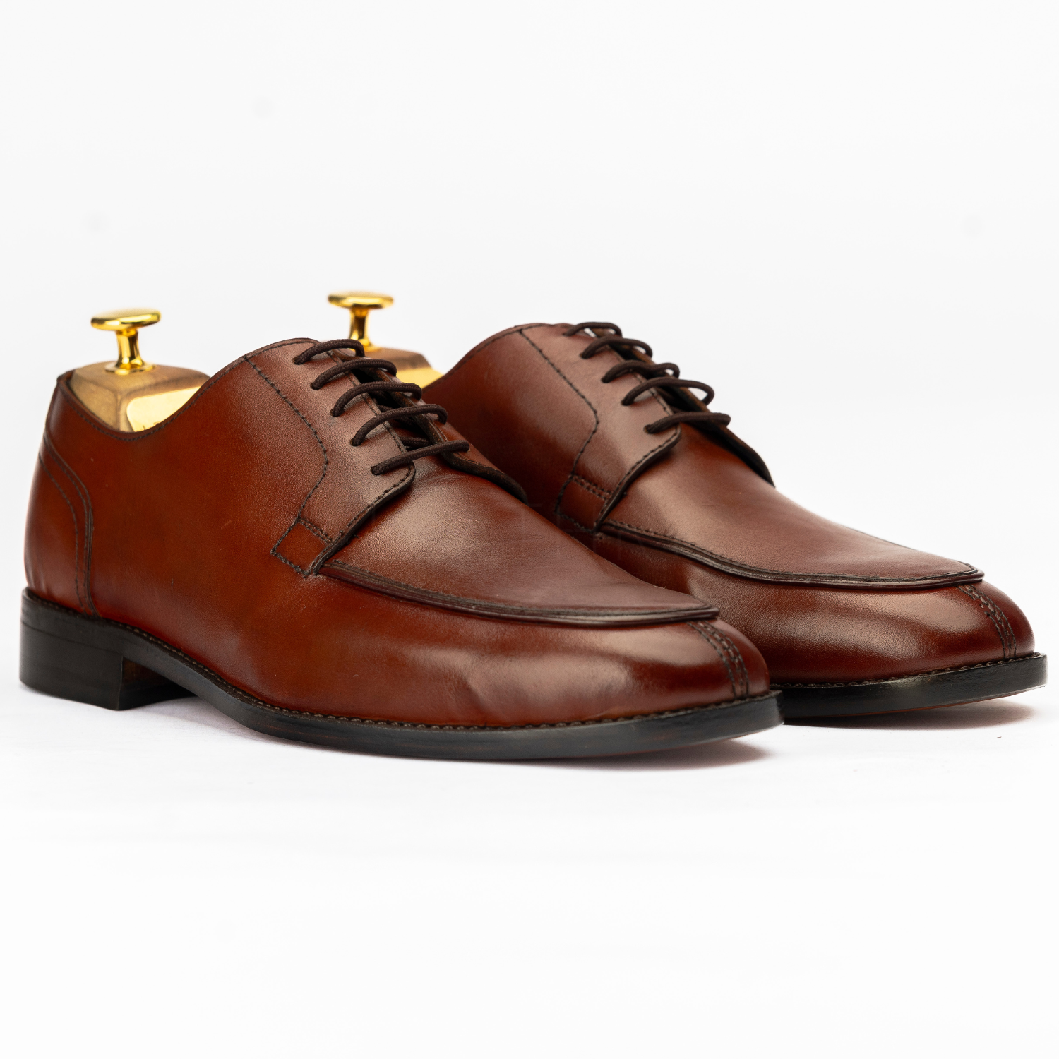 Pair of brown leather dress shoes on a white background