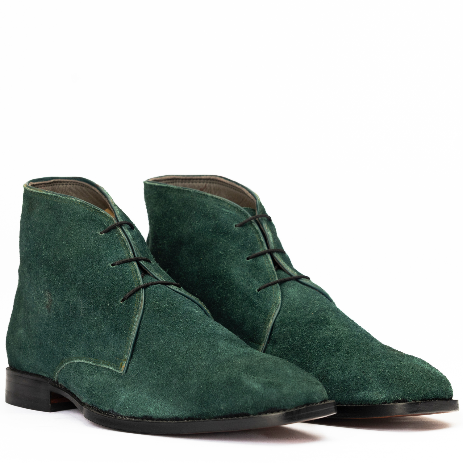 Pair of green suede boots on a white background