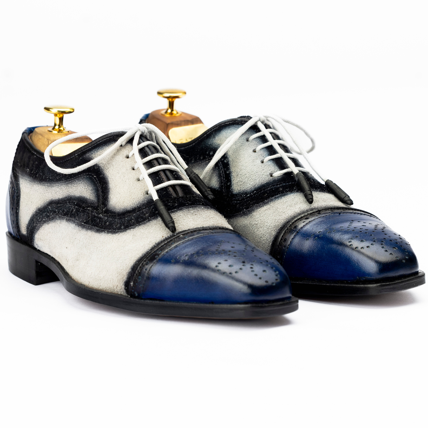 Pair of black and white shoes with blue soles on a white background