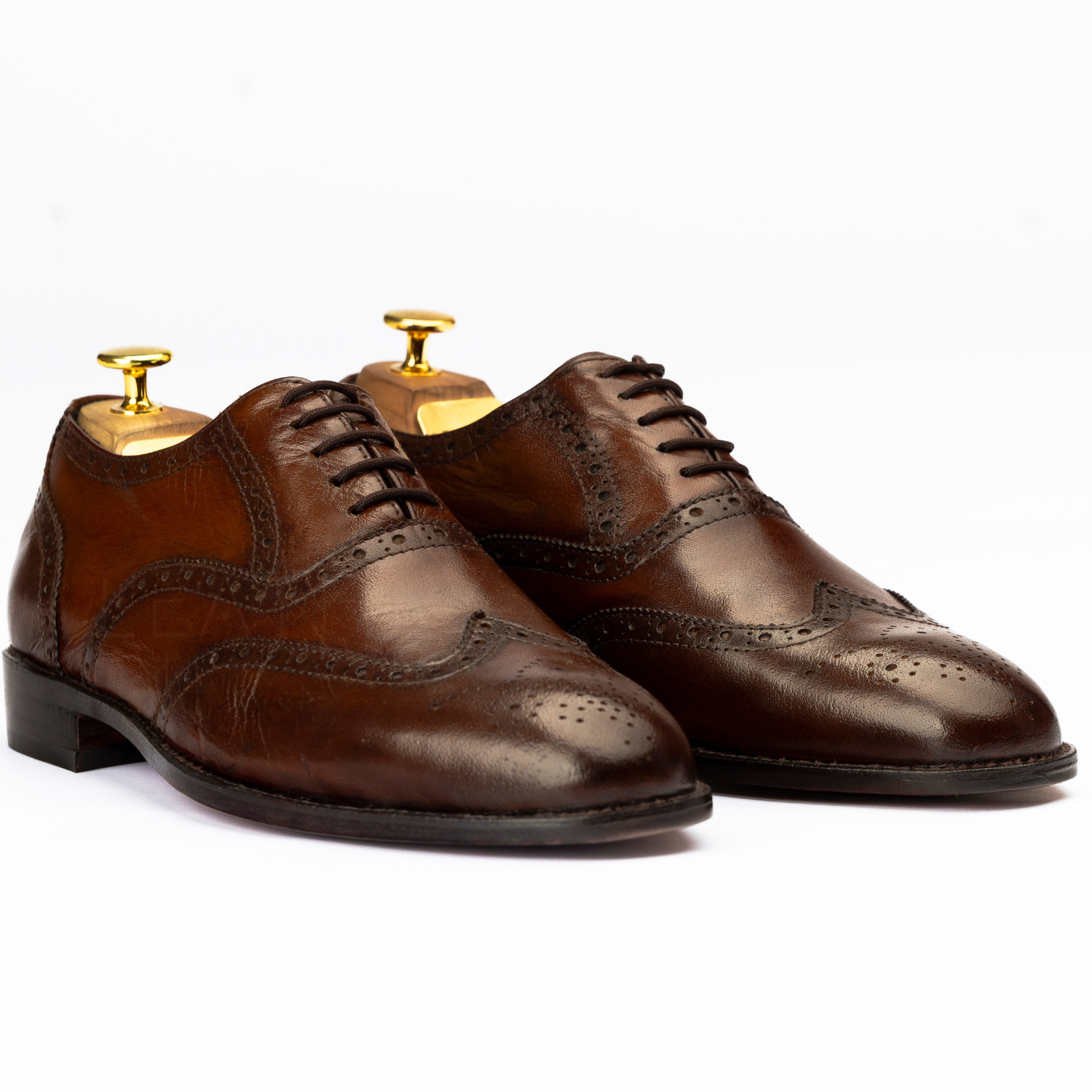 Pair of brown leather dress shoes on a white background
