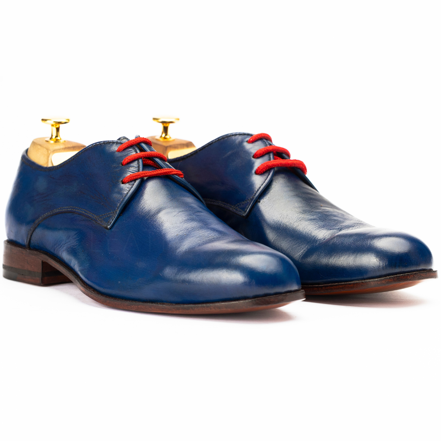 Pair of blue leather shoes with red laces on a white background