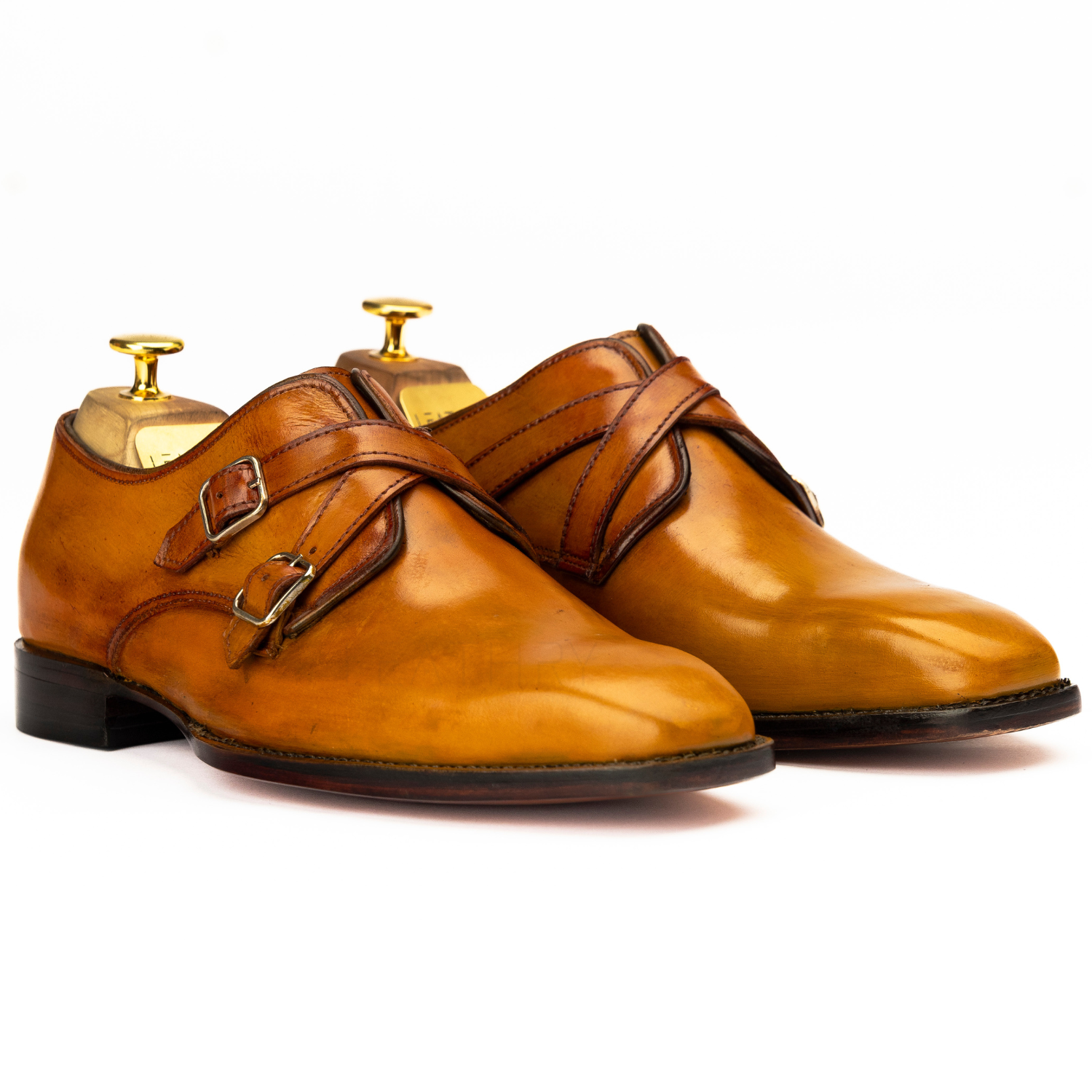 Pair of brown leather shoes with gold buckles on a white background