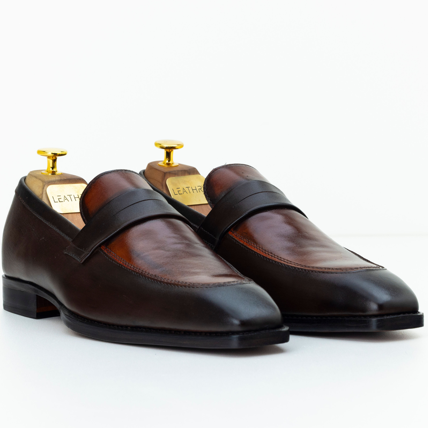Pair of brown leather loafers on a white background