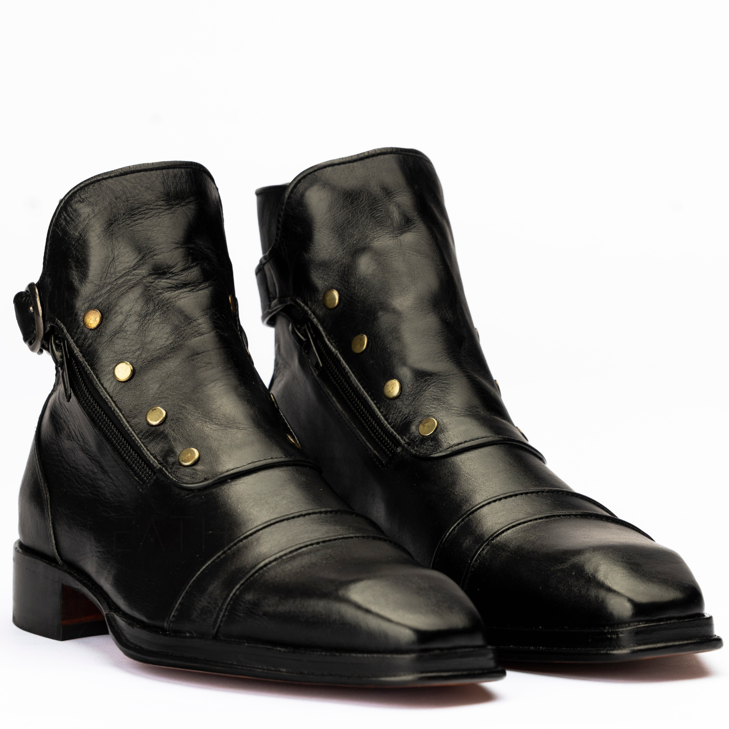 Pair of black leather boots with gold buttons on a white background