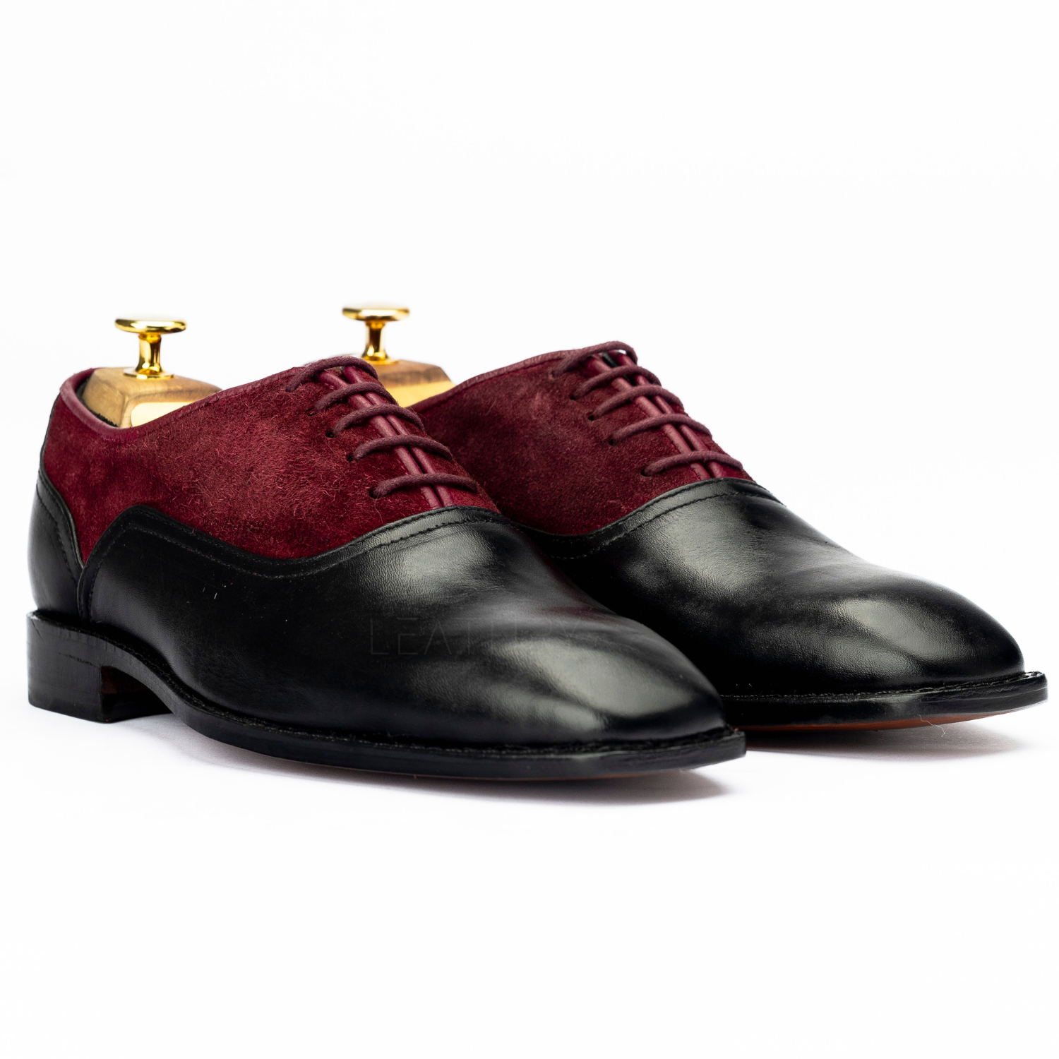 Pair of maroon and black dress shoes on a white background