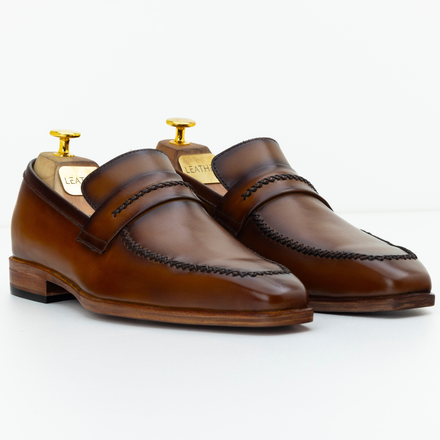 Pair of brown leather loafers on a white background