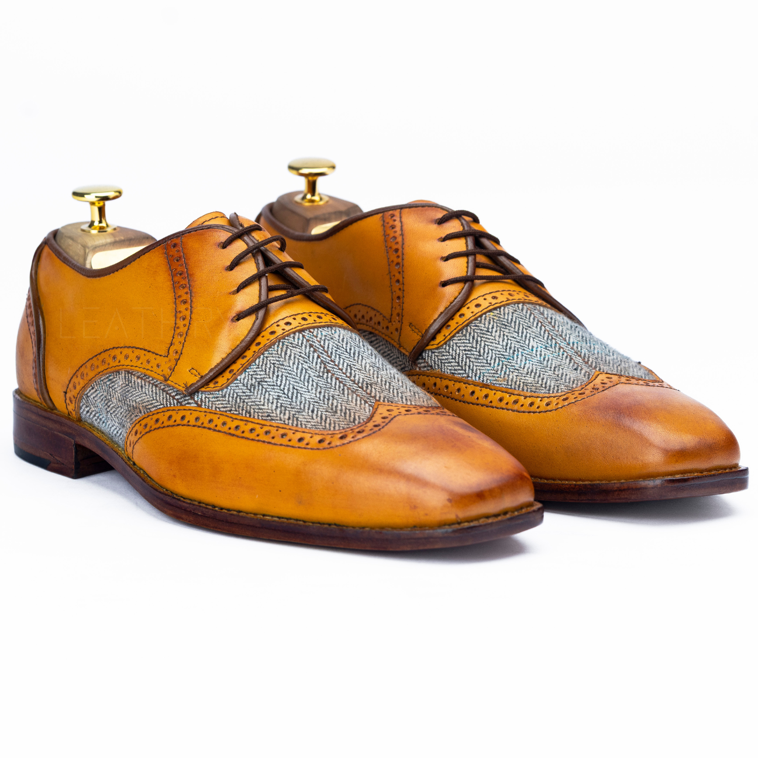 Pair of brown leather shoes with patterned insoles on a white background