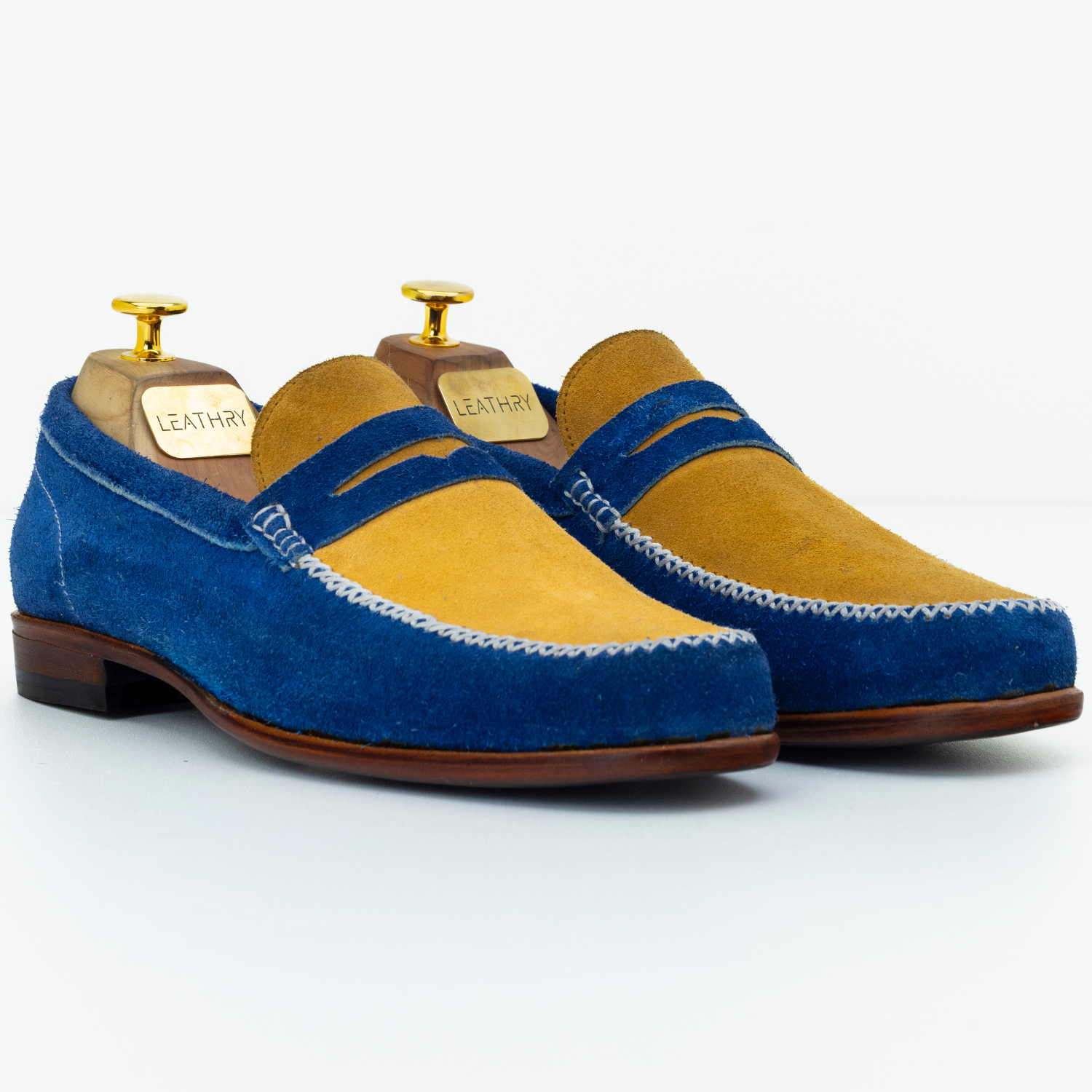 Pair of blue and yellow loafers on a white background