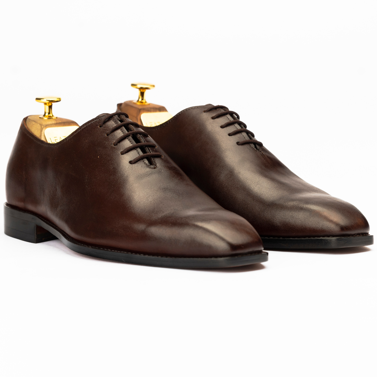 Pair of brown leather dress shoes on a white background