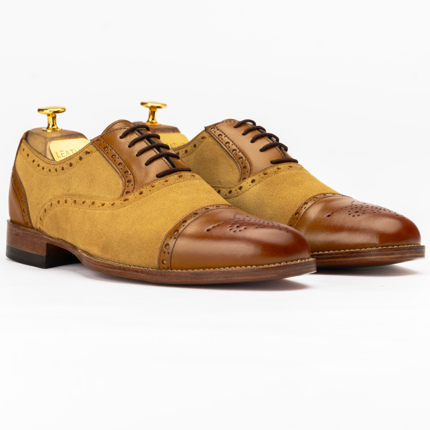 Pair of brown and tan dress shoes on a white background