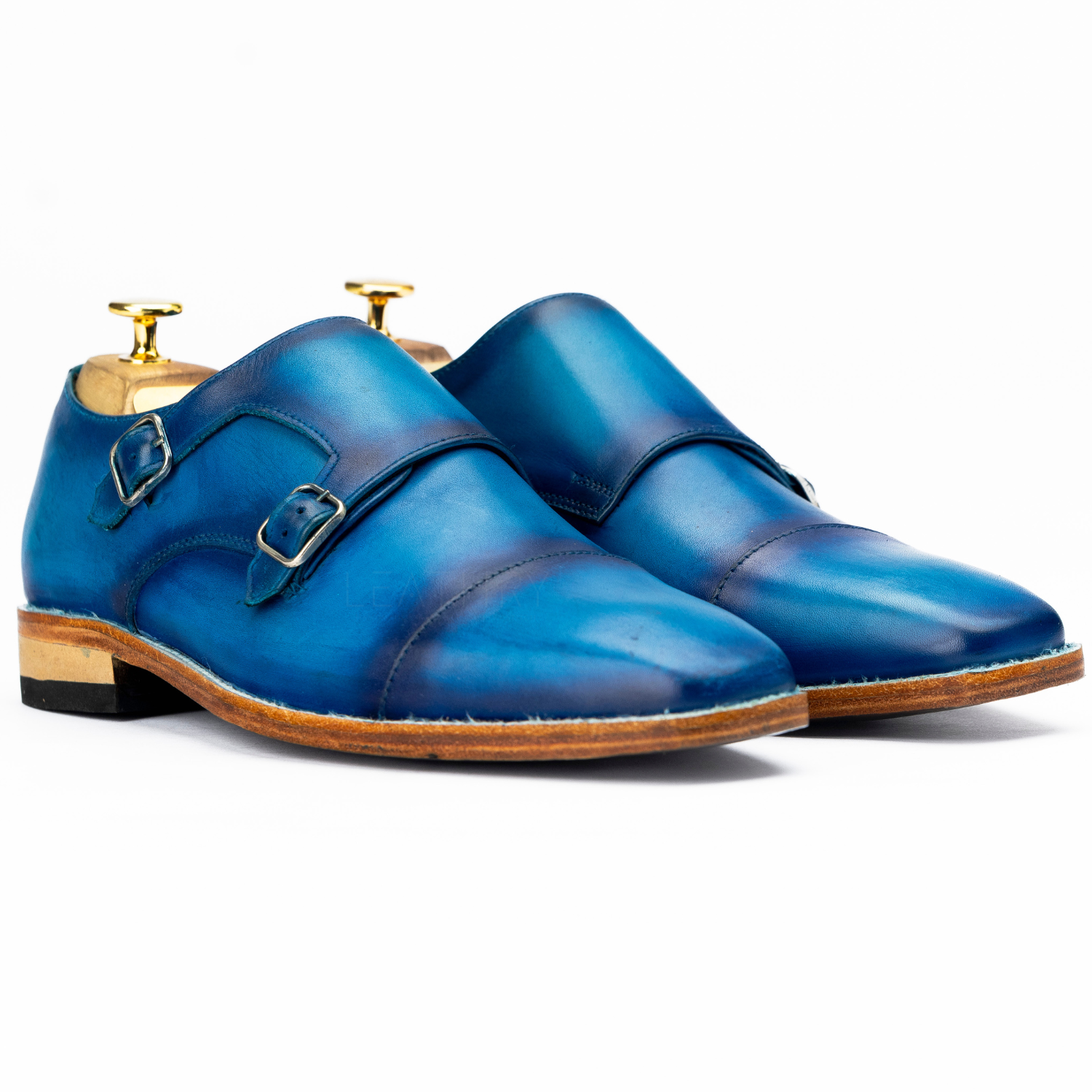 Pair of blue leather shoes with gold buckles on a white background