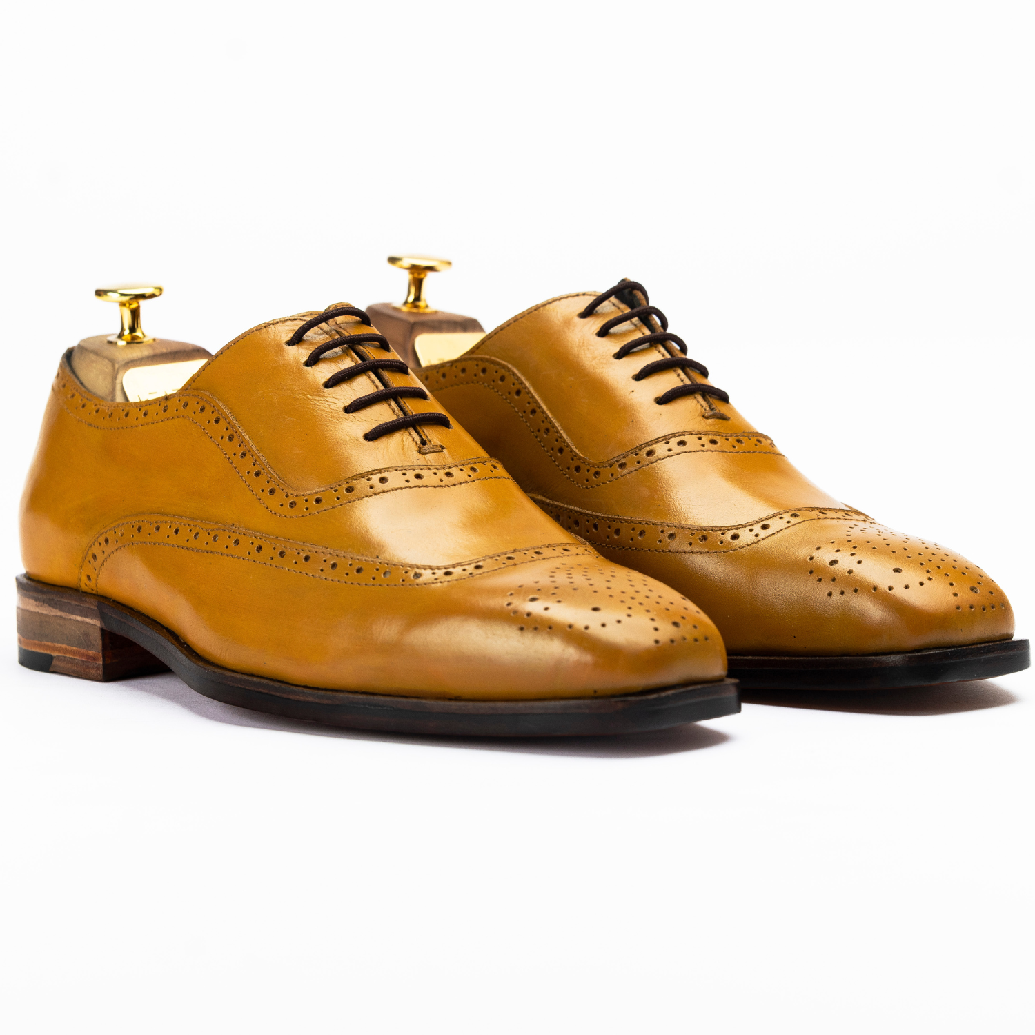 Pair of tan leather dress shoes on a white background