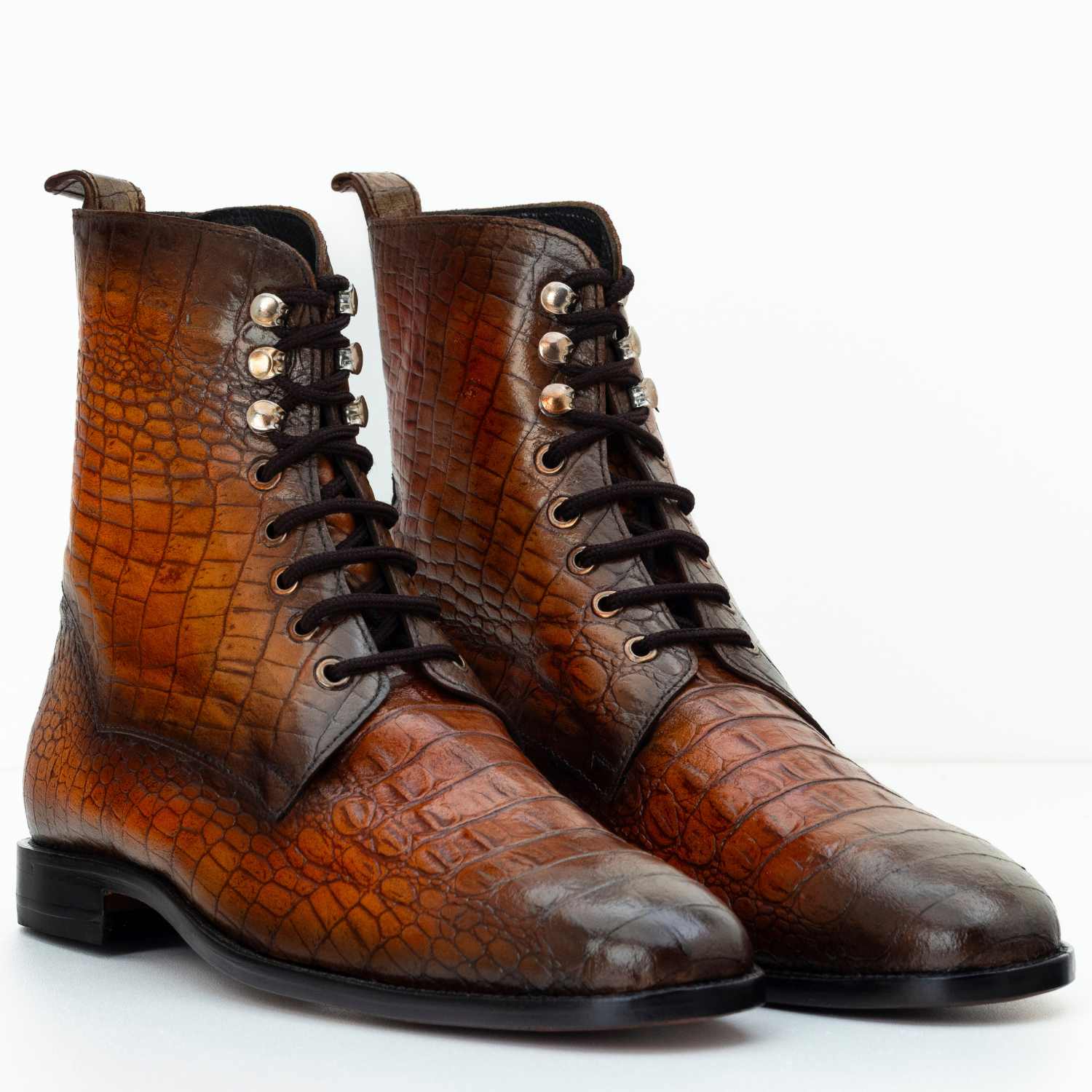 Brown leather boots with crocodile texture on a white background