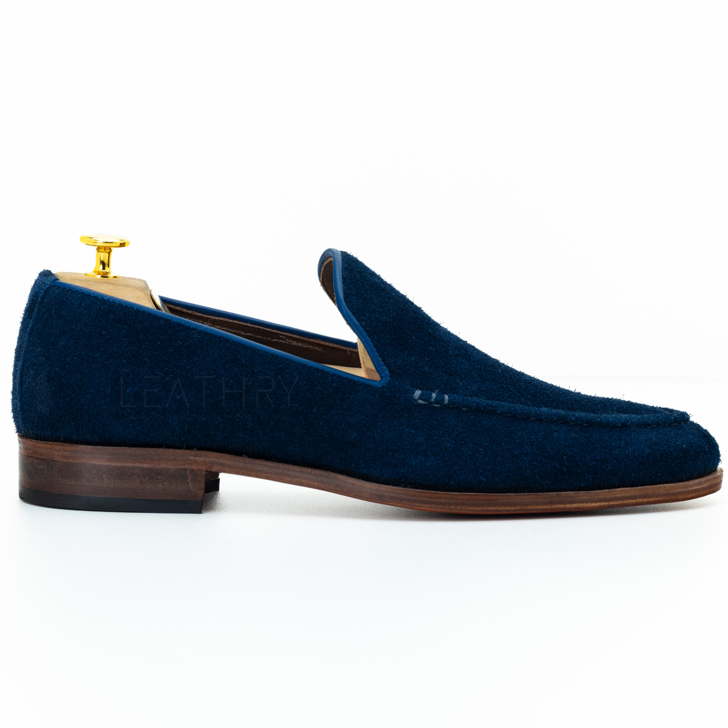 Blue suede loafer with a wooden sole on a white background
