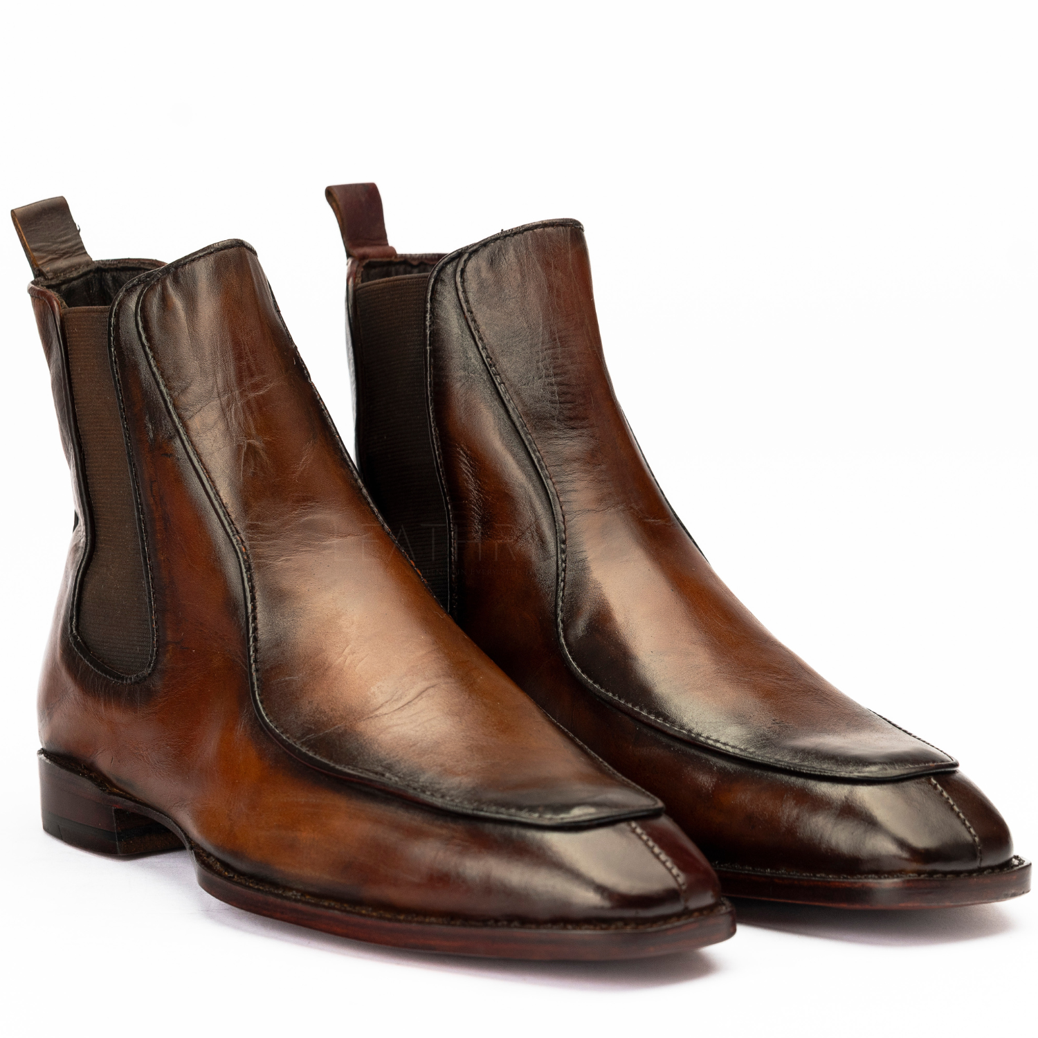 Pair of brown leather Chelsea boots on a white background