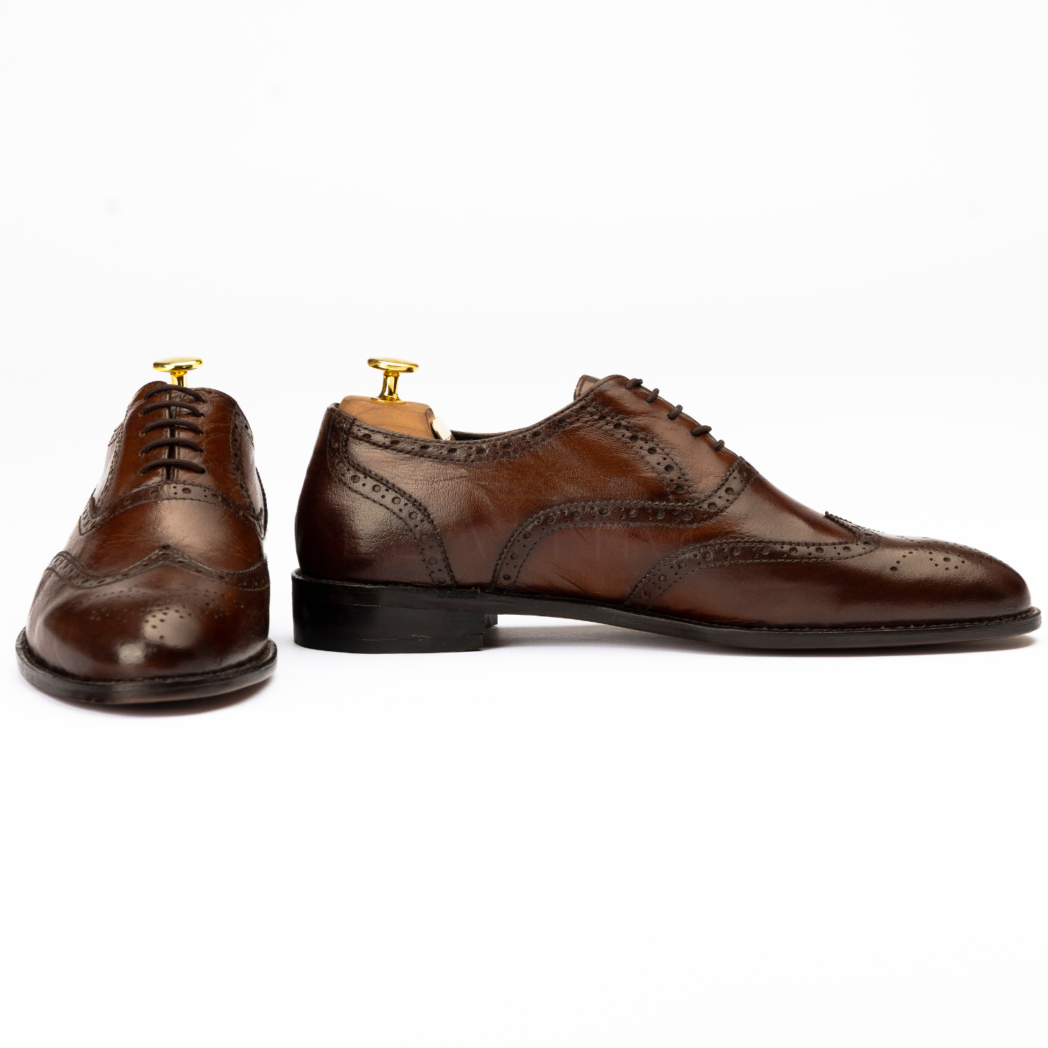 Pair of brown leather dress shoes on a white background